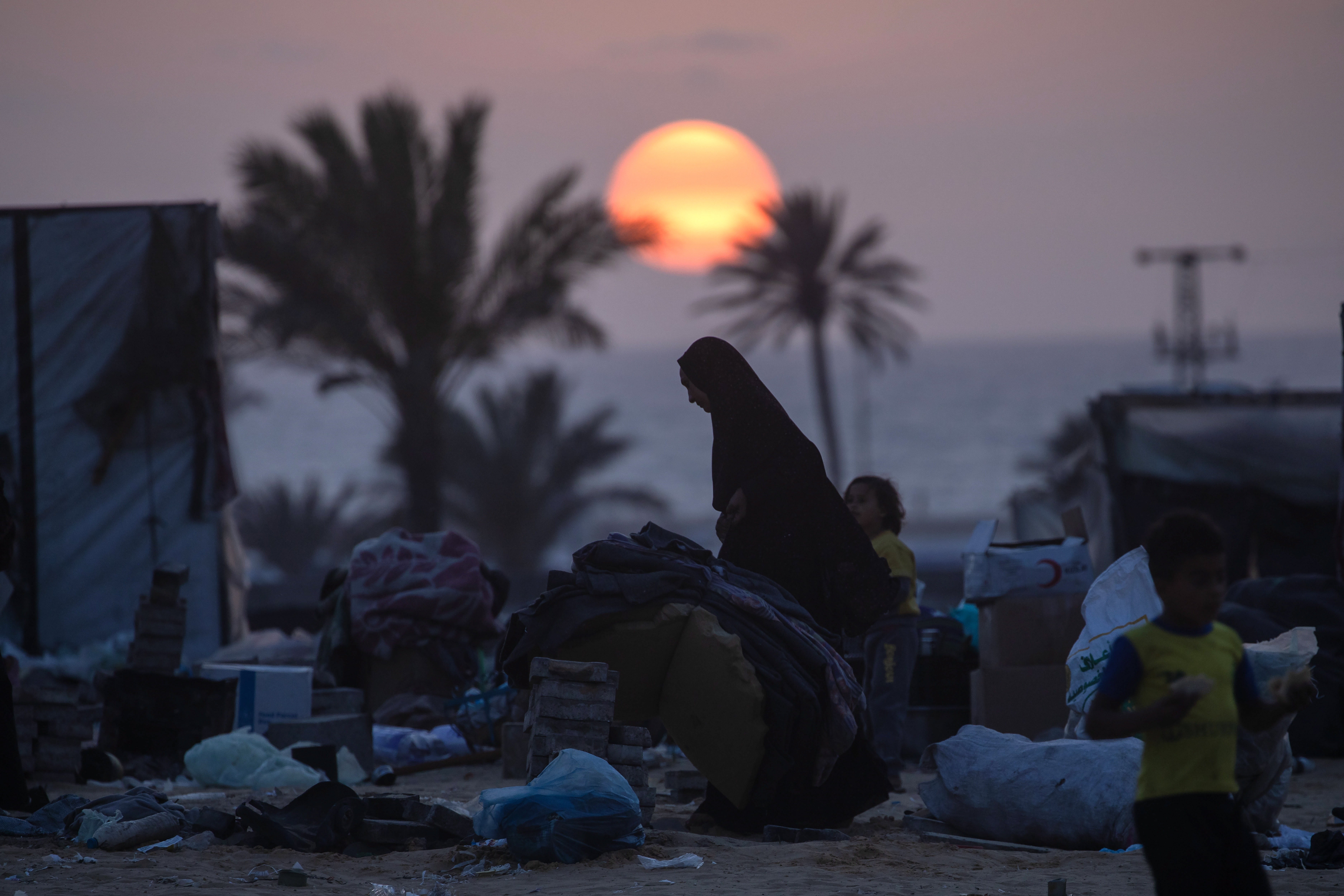 Displaced Palestinians prepare to leave with their belongings