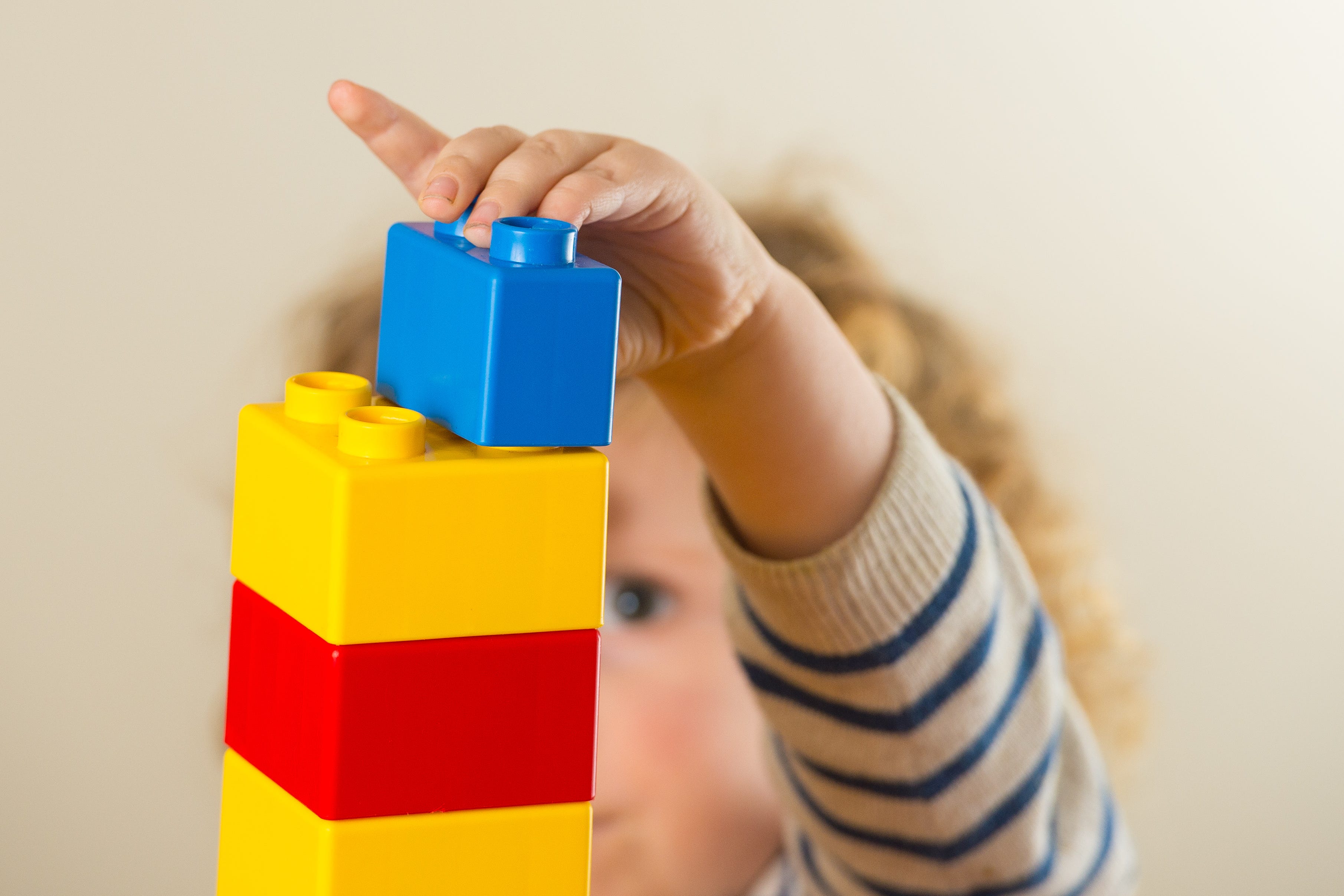 A preschool age child playing with plastic building blocks (Dominic Lipinski/PA)