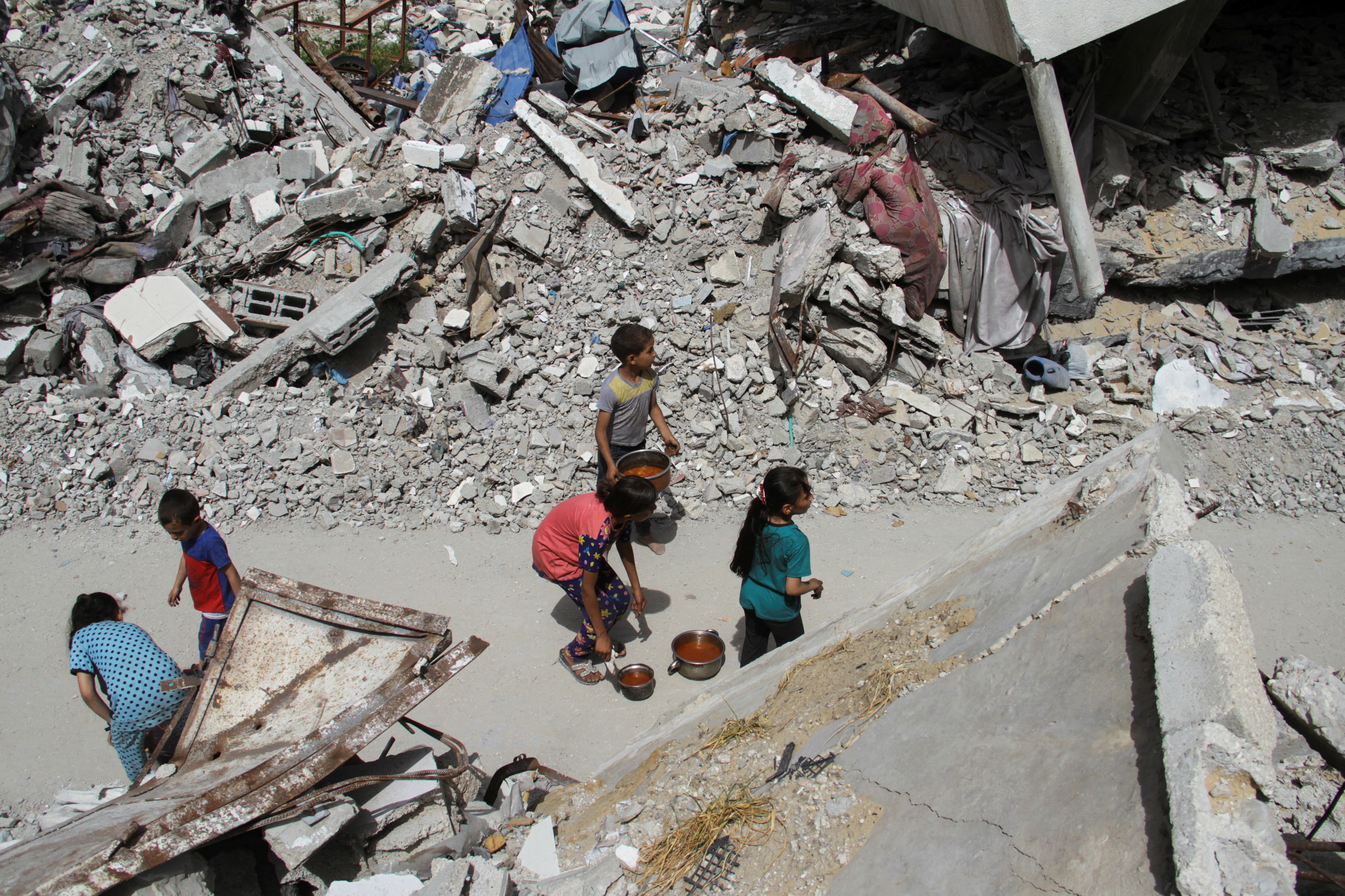 Children walk after receiving food, amid the ongoing conflict between Israel and the Palestinian Islamist group Hamas, in Jabalia, in the northern Gaza Strip April 22, 2024