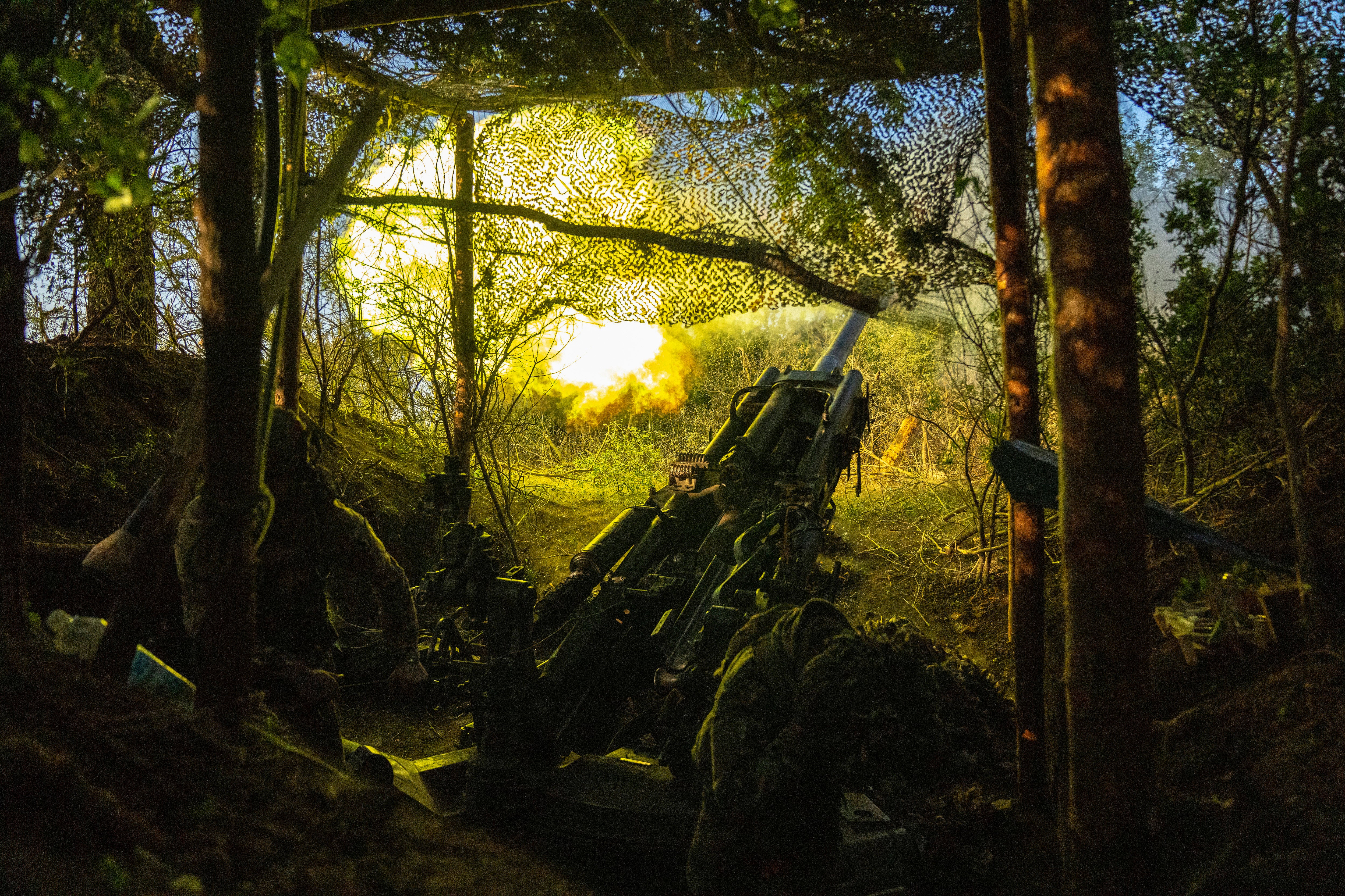 Ukrainian soldiers fire towards Russian positions on the front line