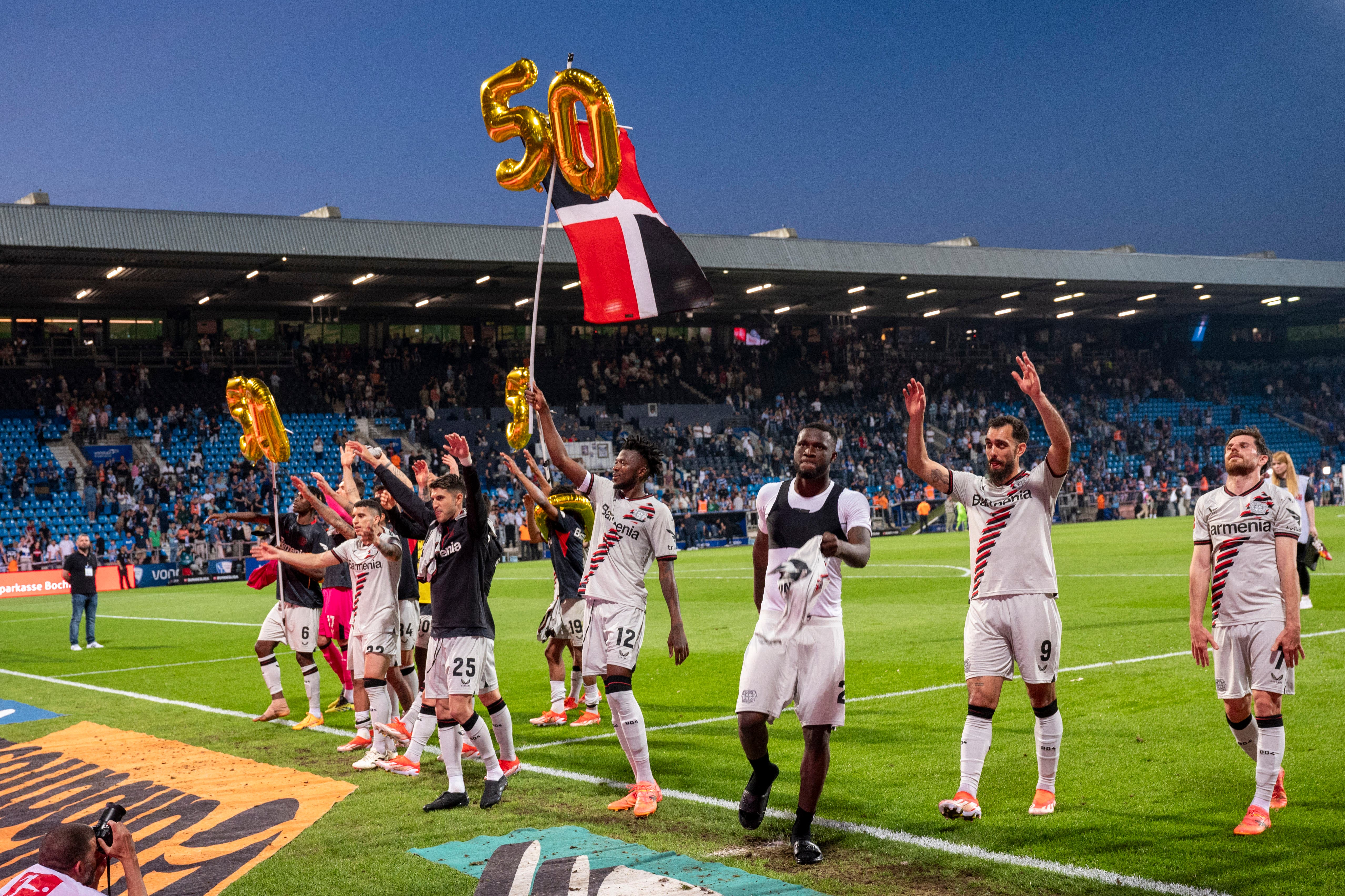 Bayer Leverkusen’s players celebrate 50 undefeated matches in a row after victory at Bochum (David Inderlied/dpa via AP)