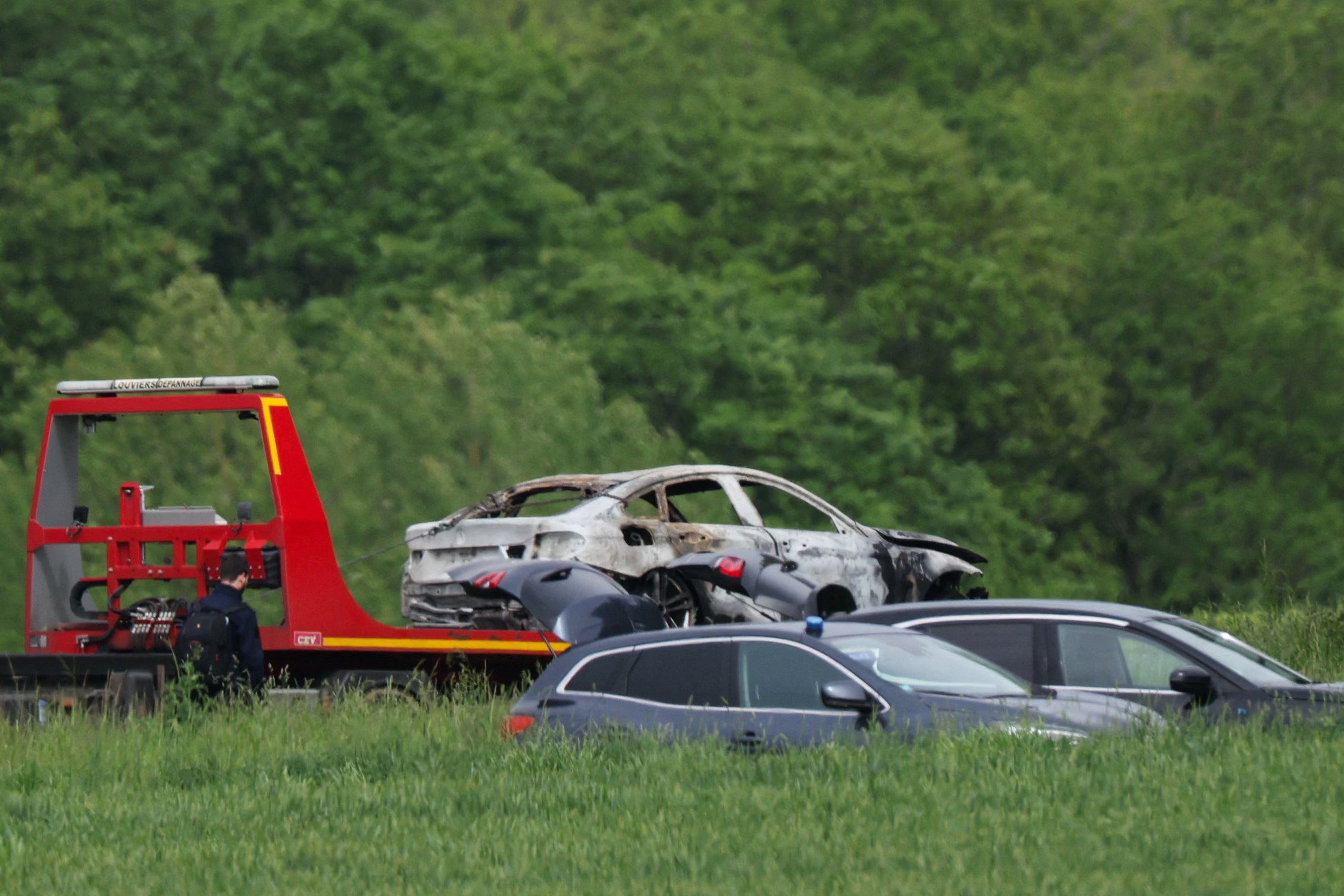 French authorities tow a burnt out vehicle used in the attack