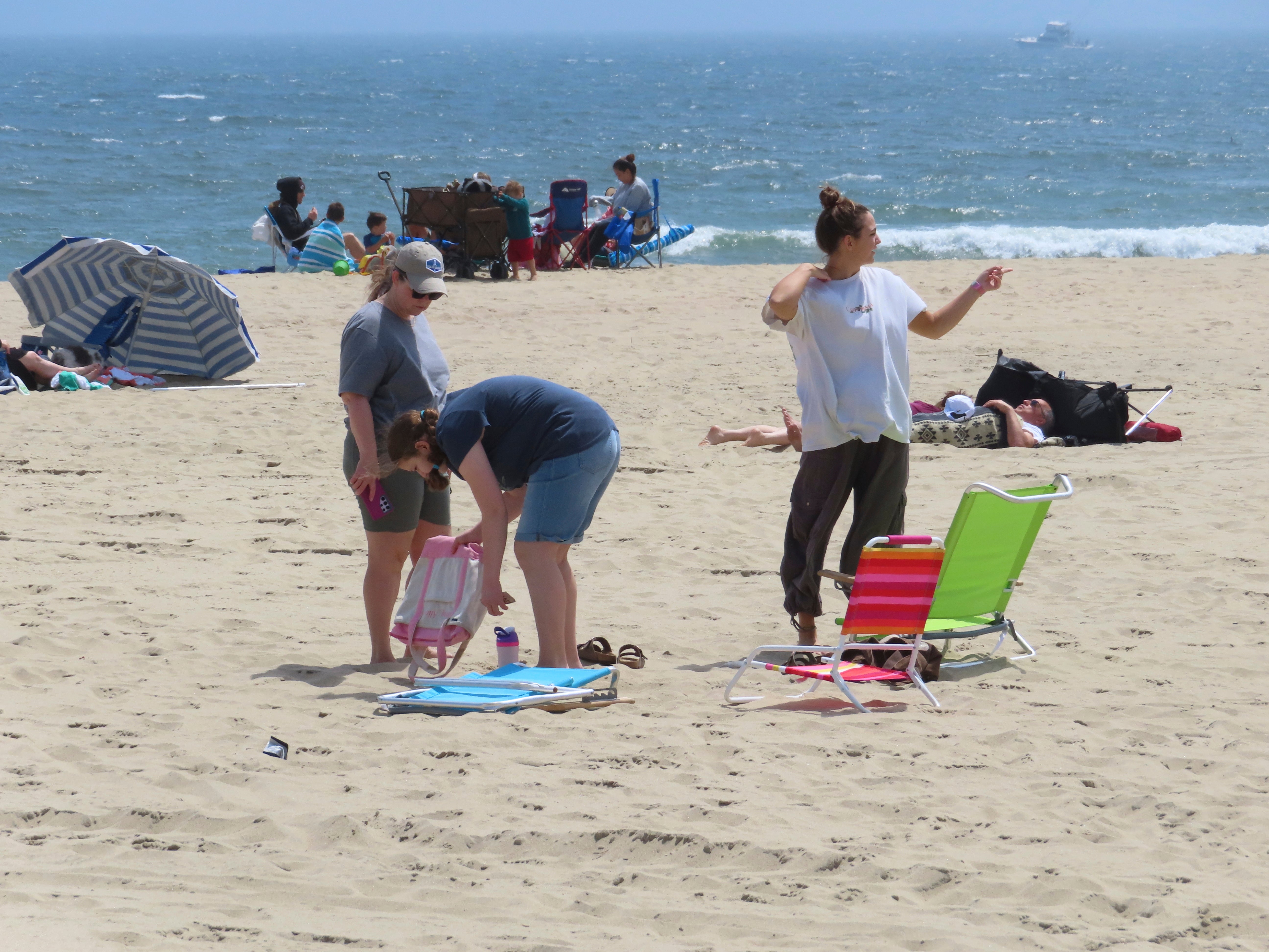 People sit on the beach on a weekday afternoon in Ocean Grove, N.J. on May 2, 2024