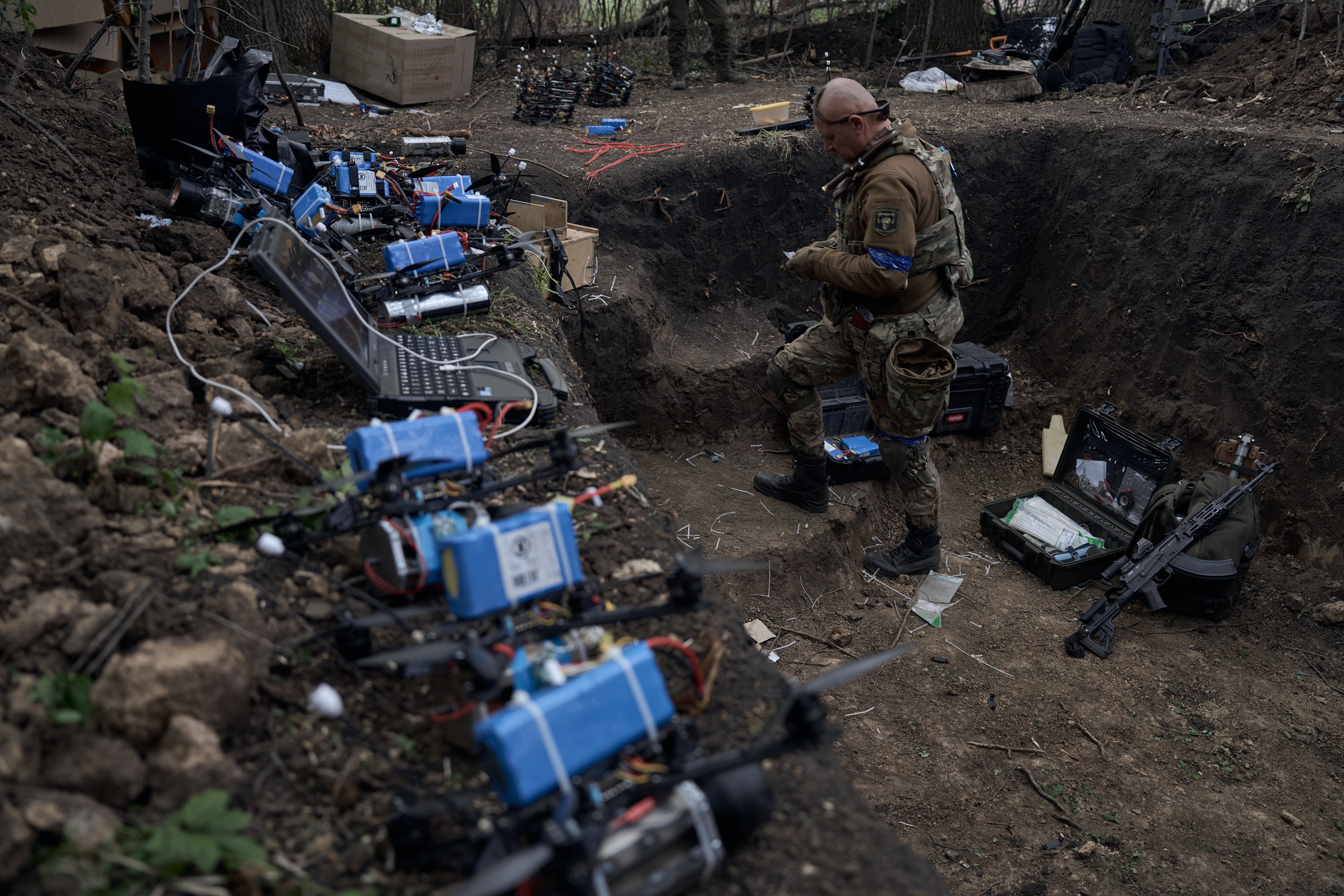 A pilot of the ‘Sharp Kartuza’ division of FPV kamikaze drones mans a dugout filled with explosives near the Russian border