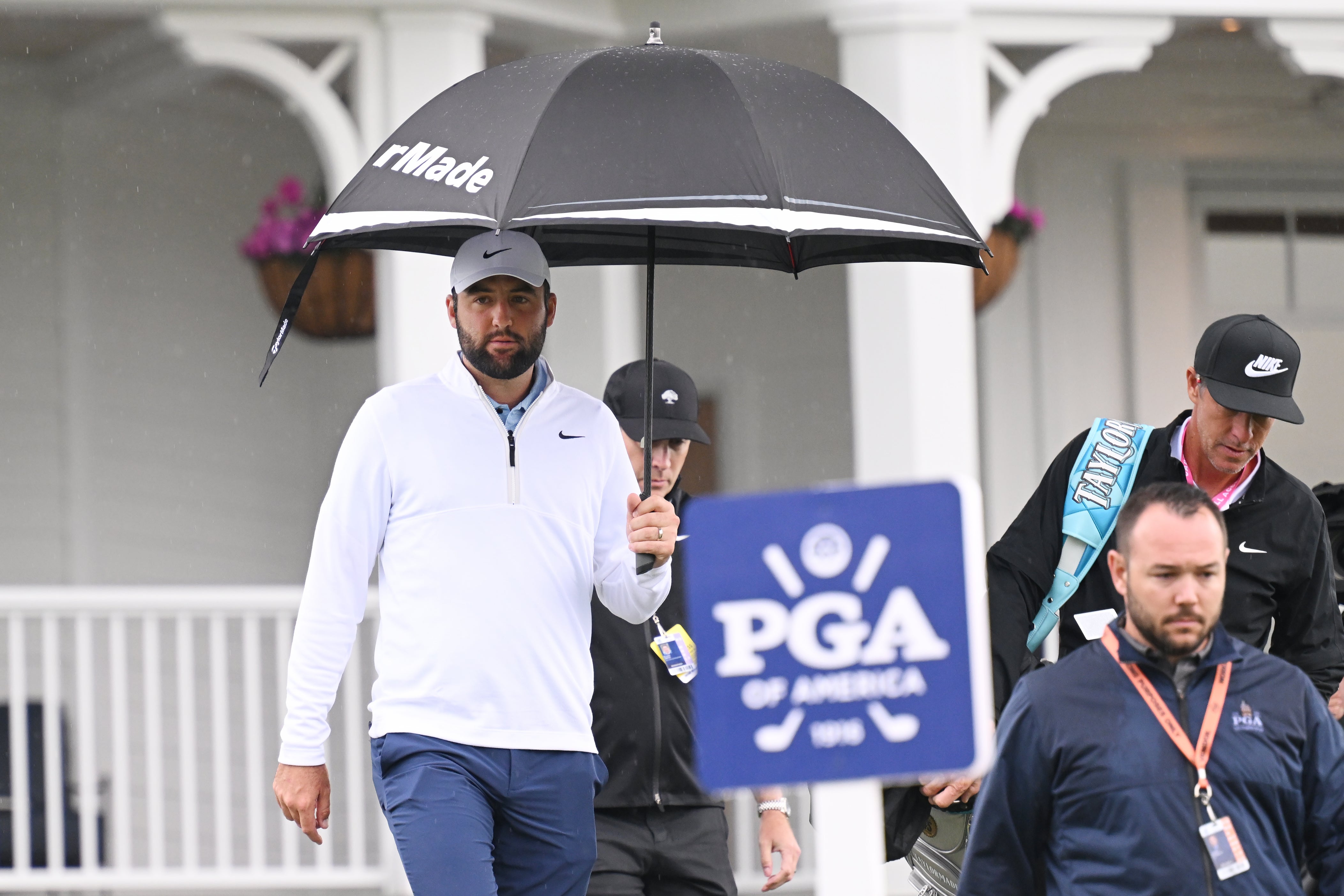 Scheffler and his caddie, Ted Scott, walk to the driving range