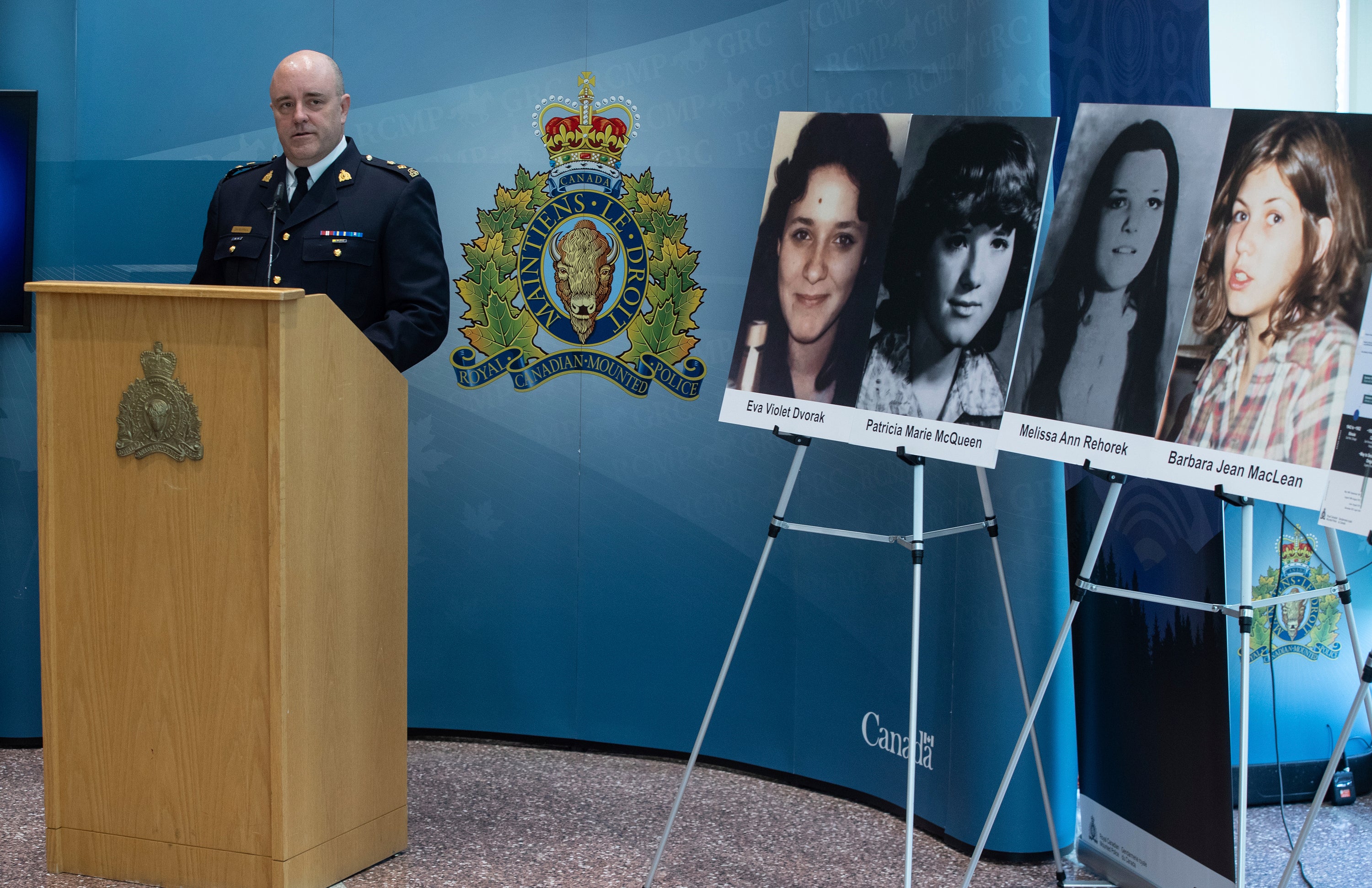 RCMP Superintendent serious crimes branch David Hall speaking next to the photos the victims murdered by Srery, Eva Dvorak and Patricia McQueen Melissa Rehorek Barbara MacLean