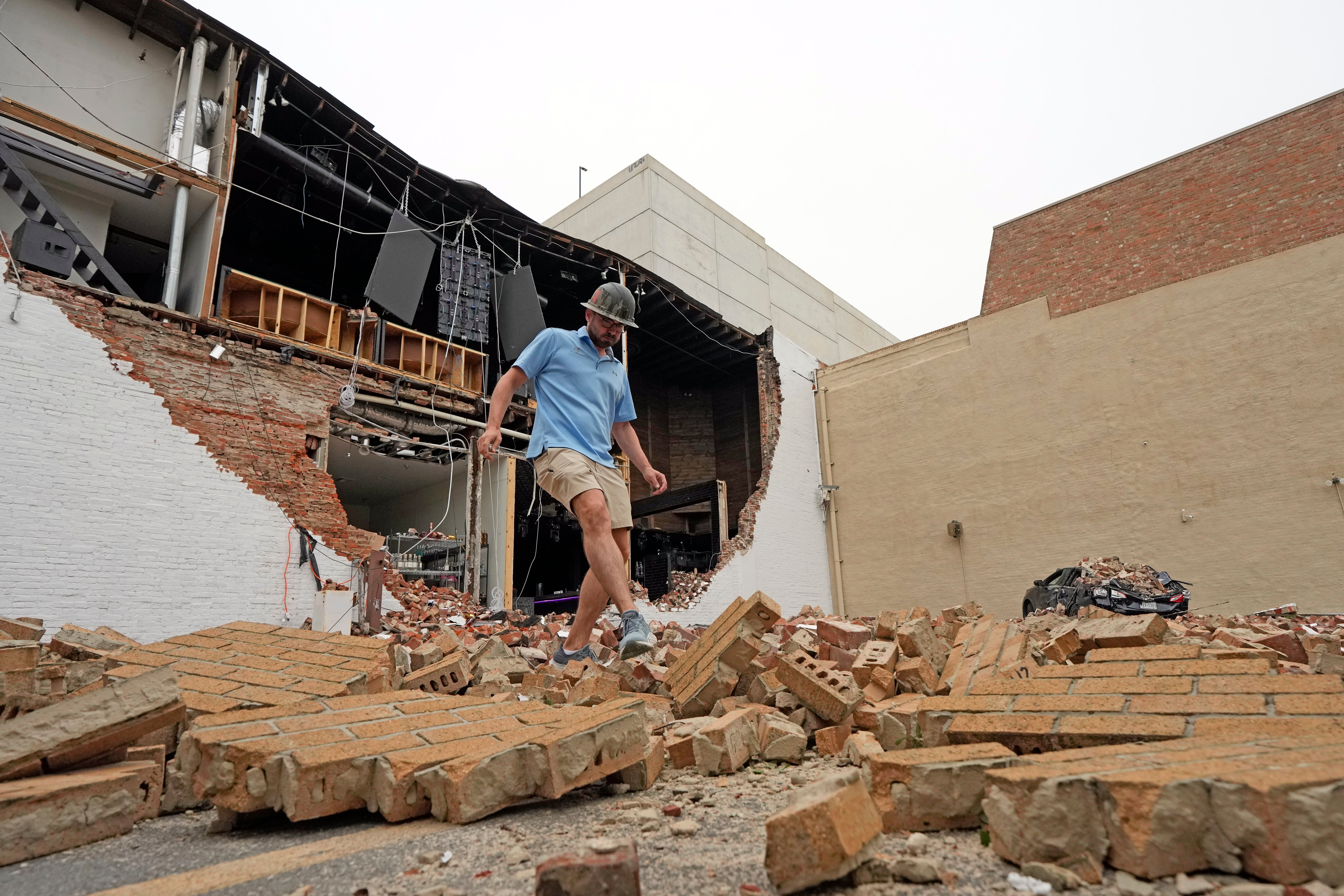 A man walks over fallen bricks from a damaged building in the aftermath of a severe thunderstorm May in Houston