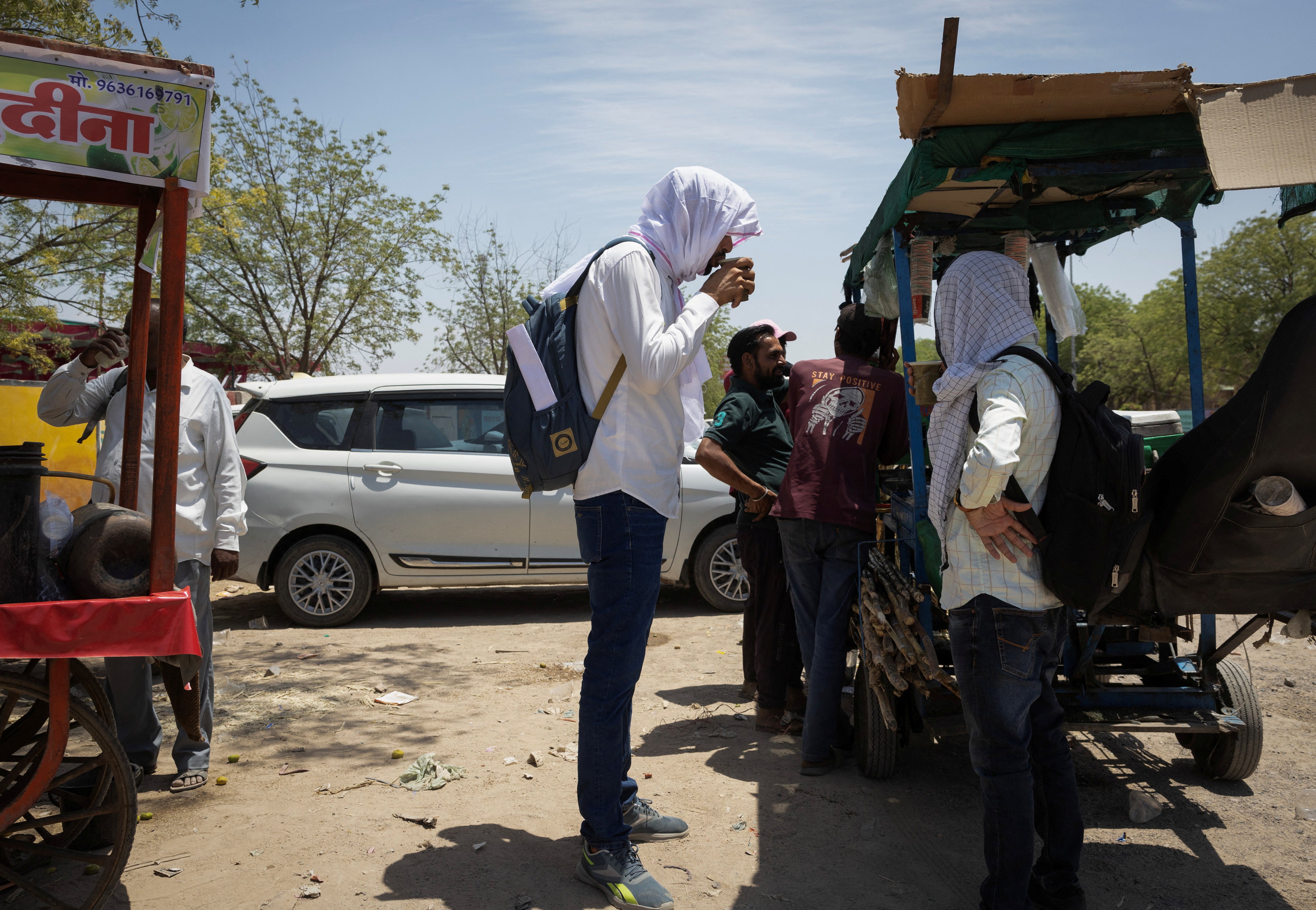 A polling officer covers himself with a scarf, to protect from heat on a hot summer day head of the second phase of the general elections, in Barmer, Rajasthan