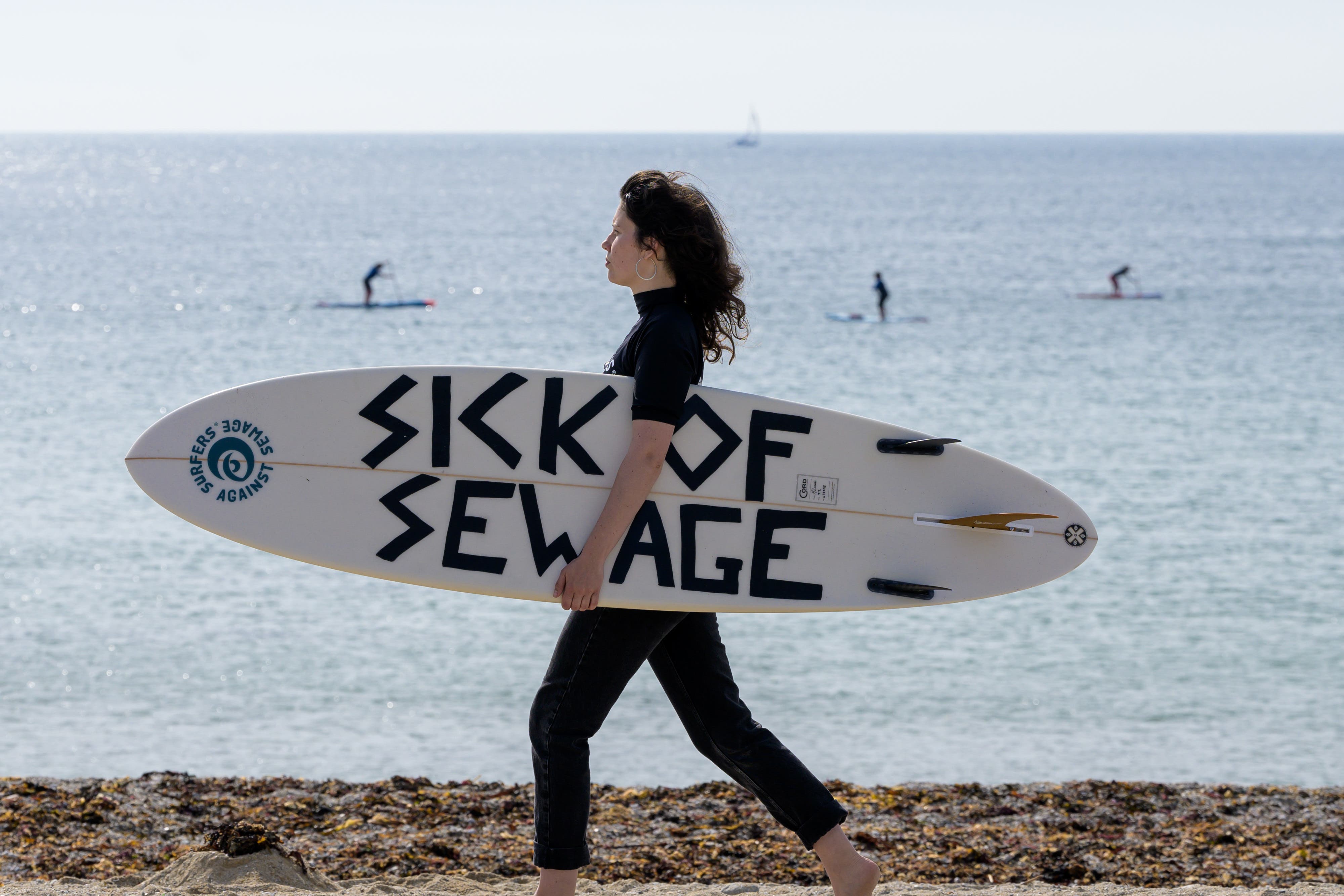 People take part in a protest by Surfers Against Sewage in Falmouth (Anthony Upton/PA Media Assignments)