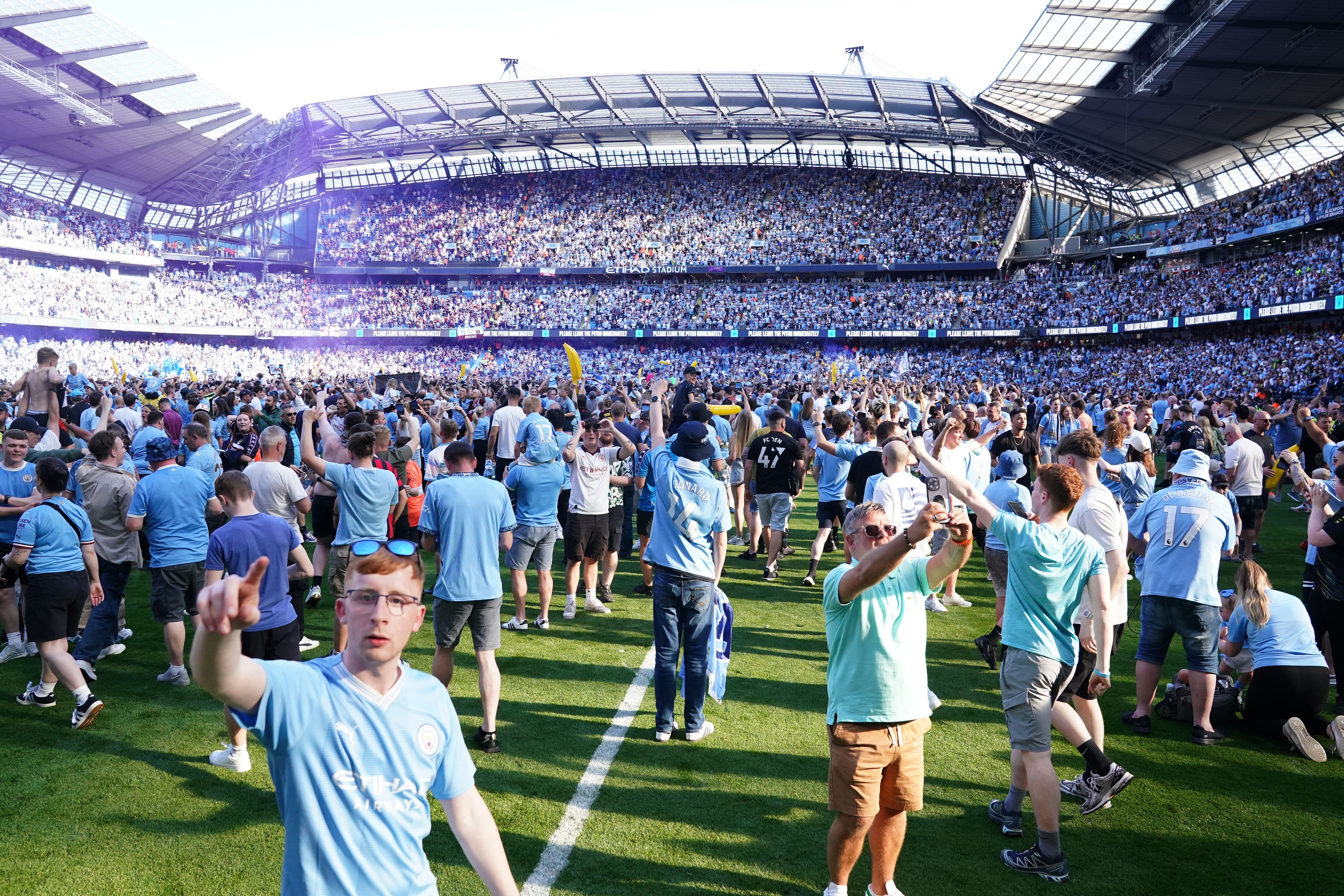 Manchester City fans invade the pitch after seeing their team clinch a fourth successive Premier League title (Martin Rickett/PA)