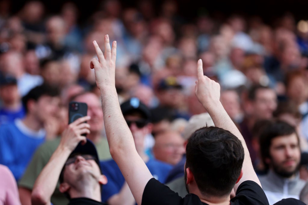 An Everton fan points out the final score at the Etihad