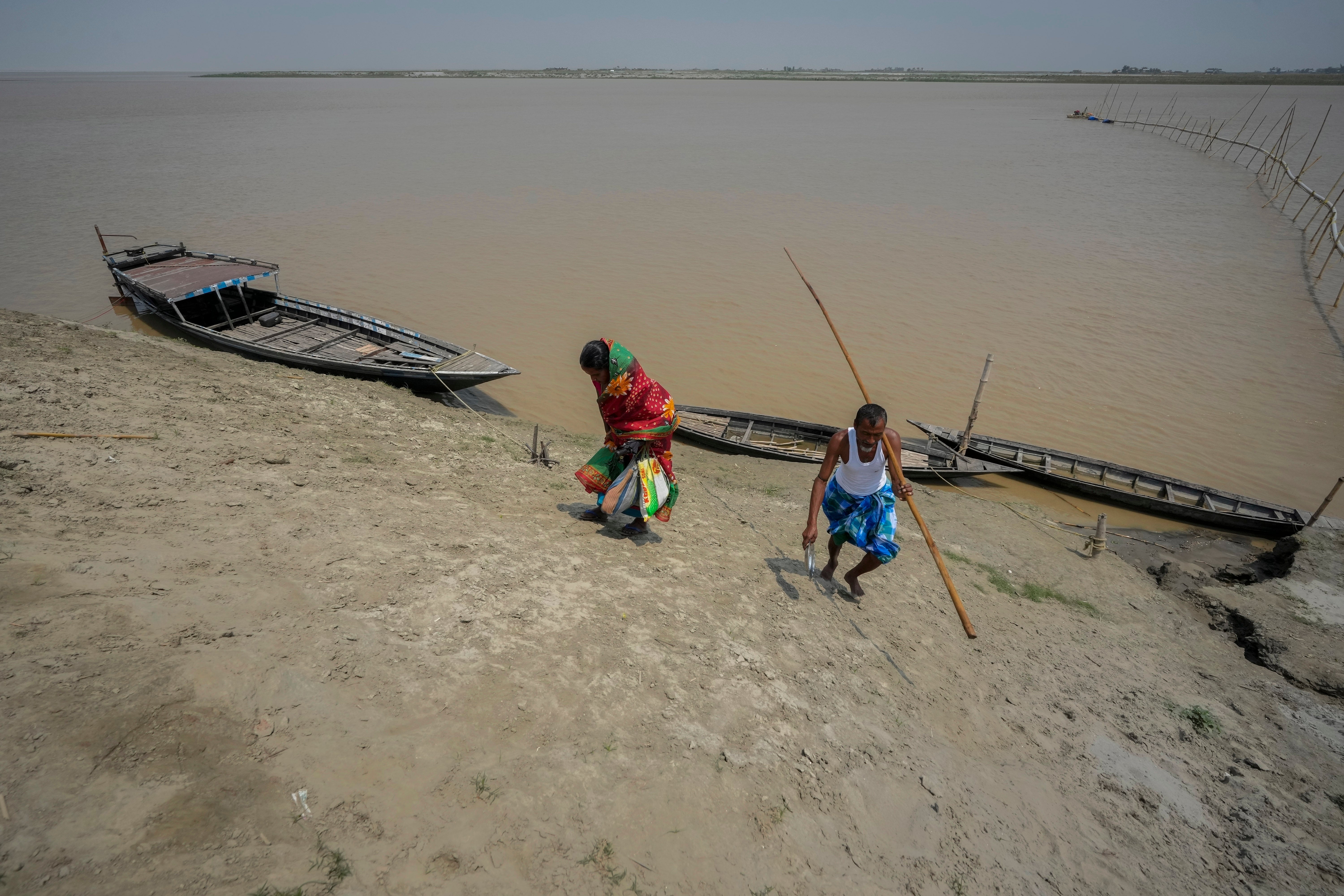 Monuwara Begum and husband Yaad Ali disembark from a boat and walk to a polling station in Assam