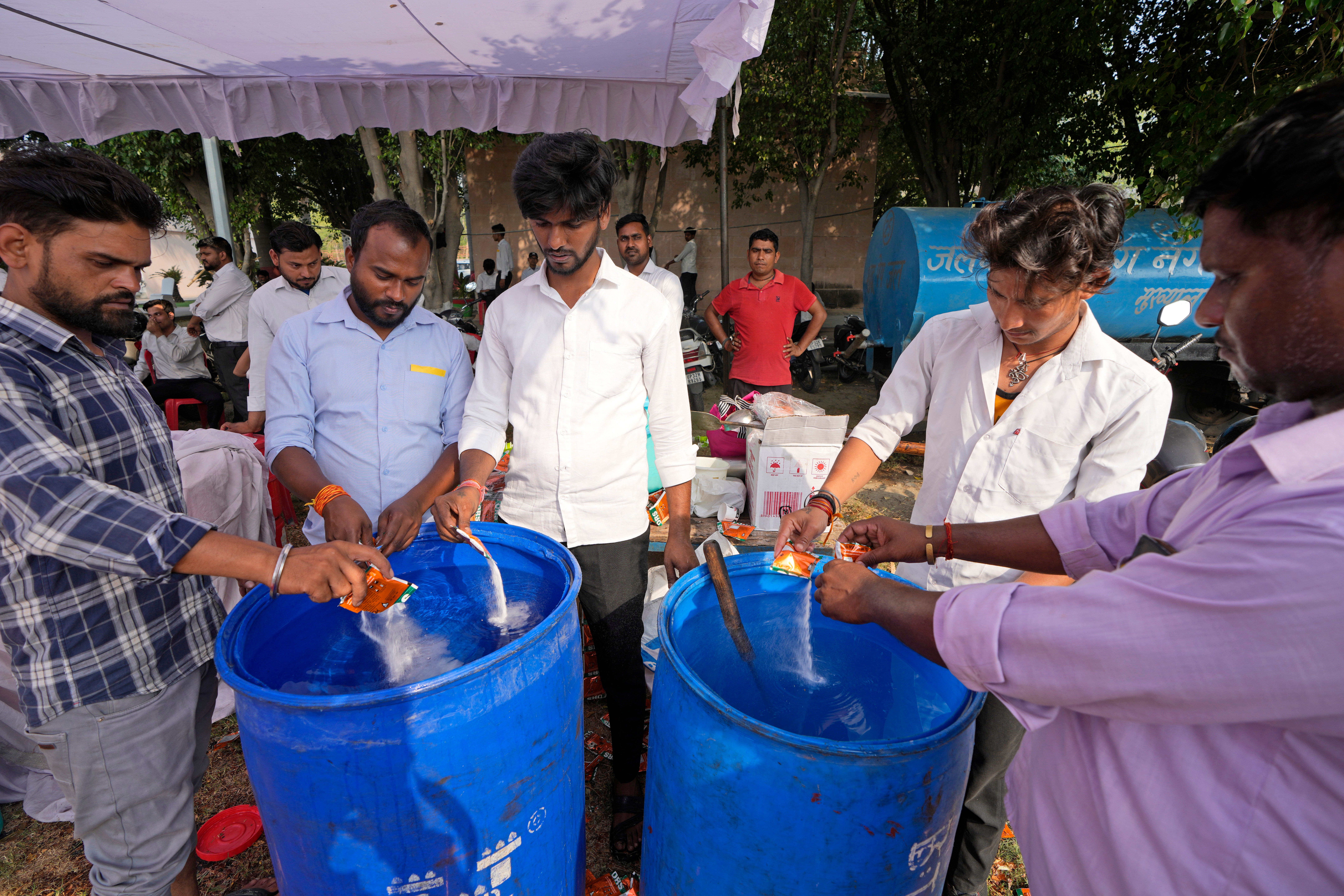 Oral rehydration salts are mixed in drinking water meant for election officials to keep them hydrated at a distribution venue for Electronic Voting Machines