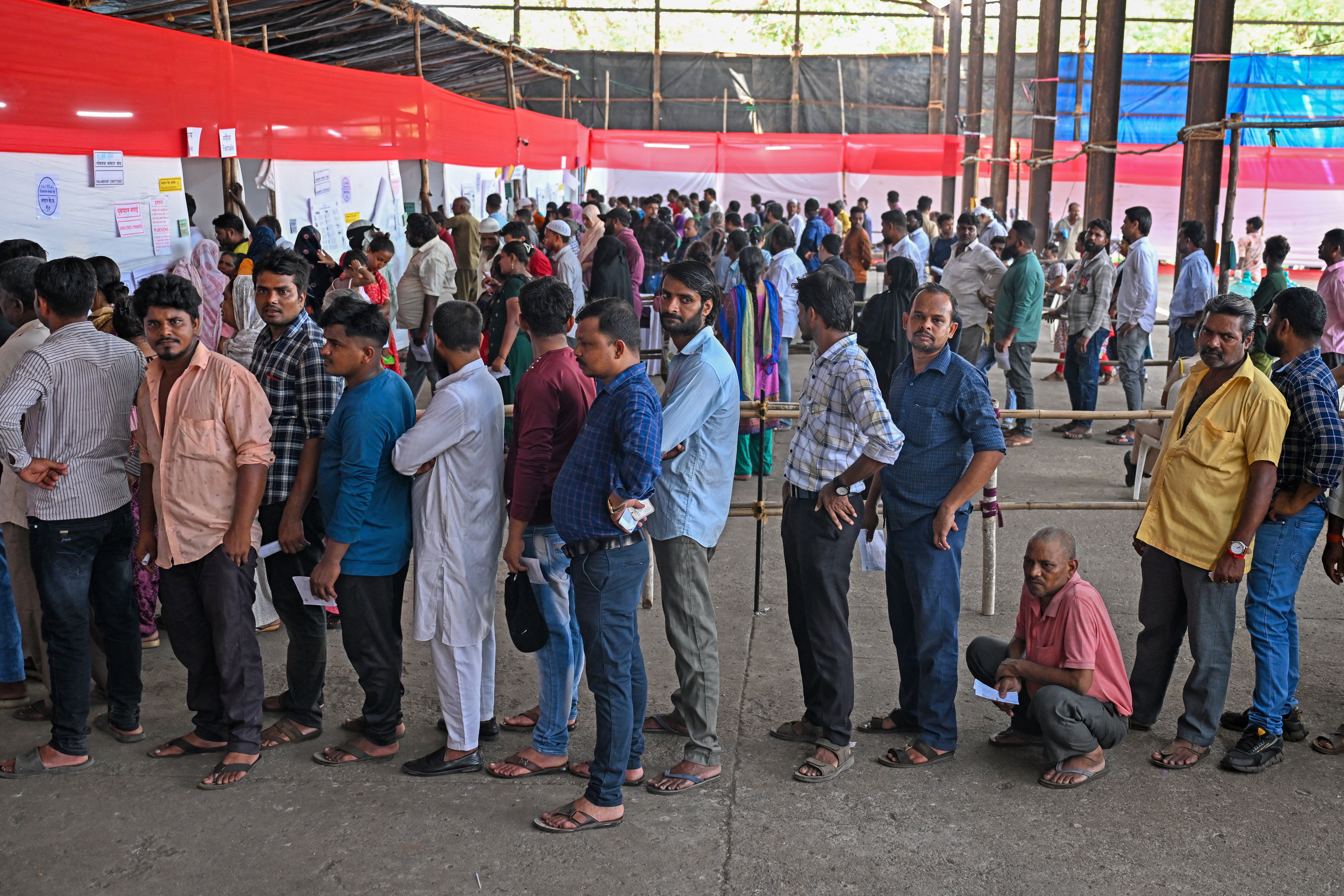 People queue up to cast their votes at a polling station in Mumbai