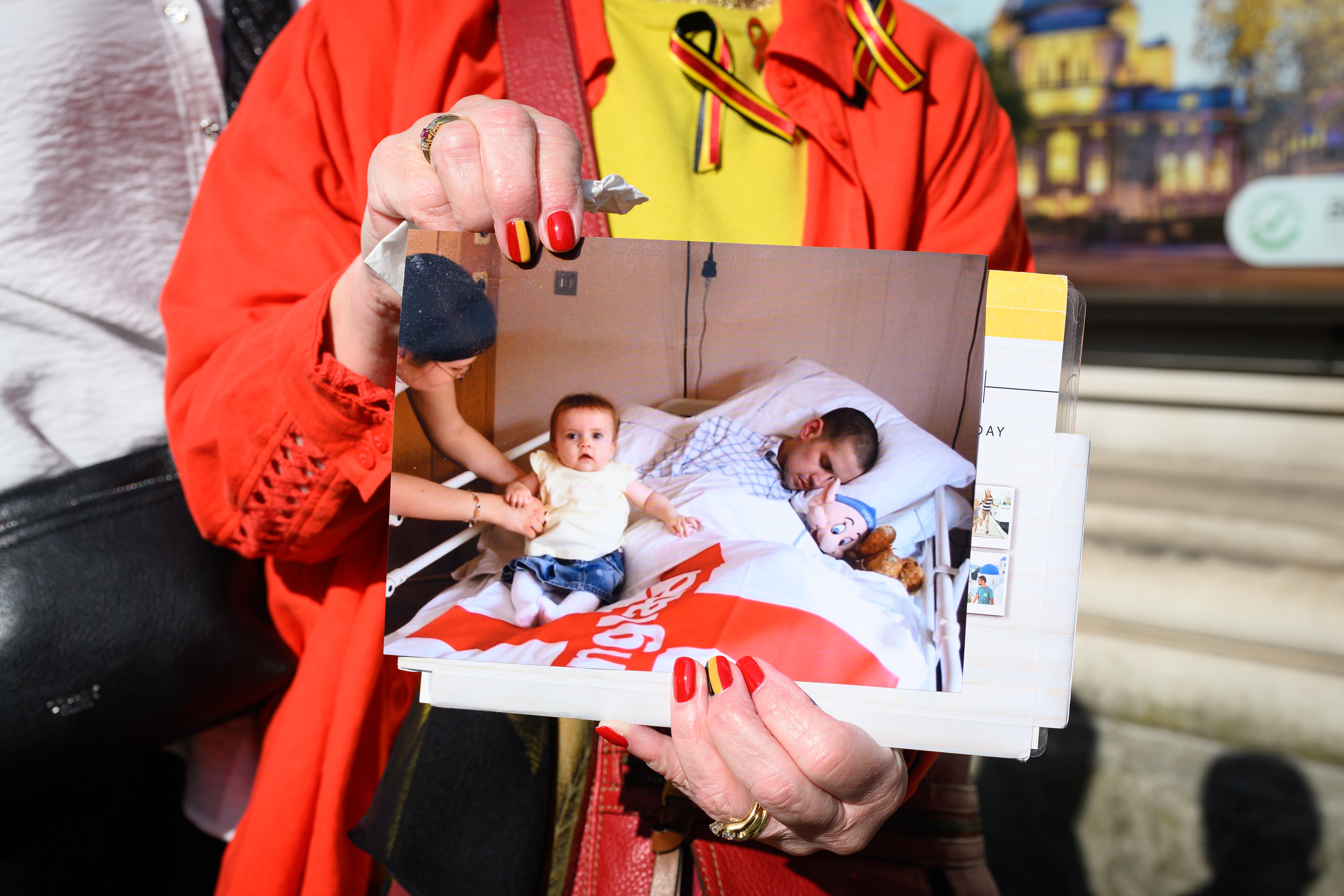 A woman holds a photograph of Marc Payton, who died in 2003 after being mistakenly infected with HIV and hepatitis C while in a children's hospital