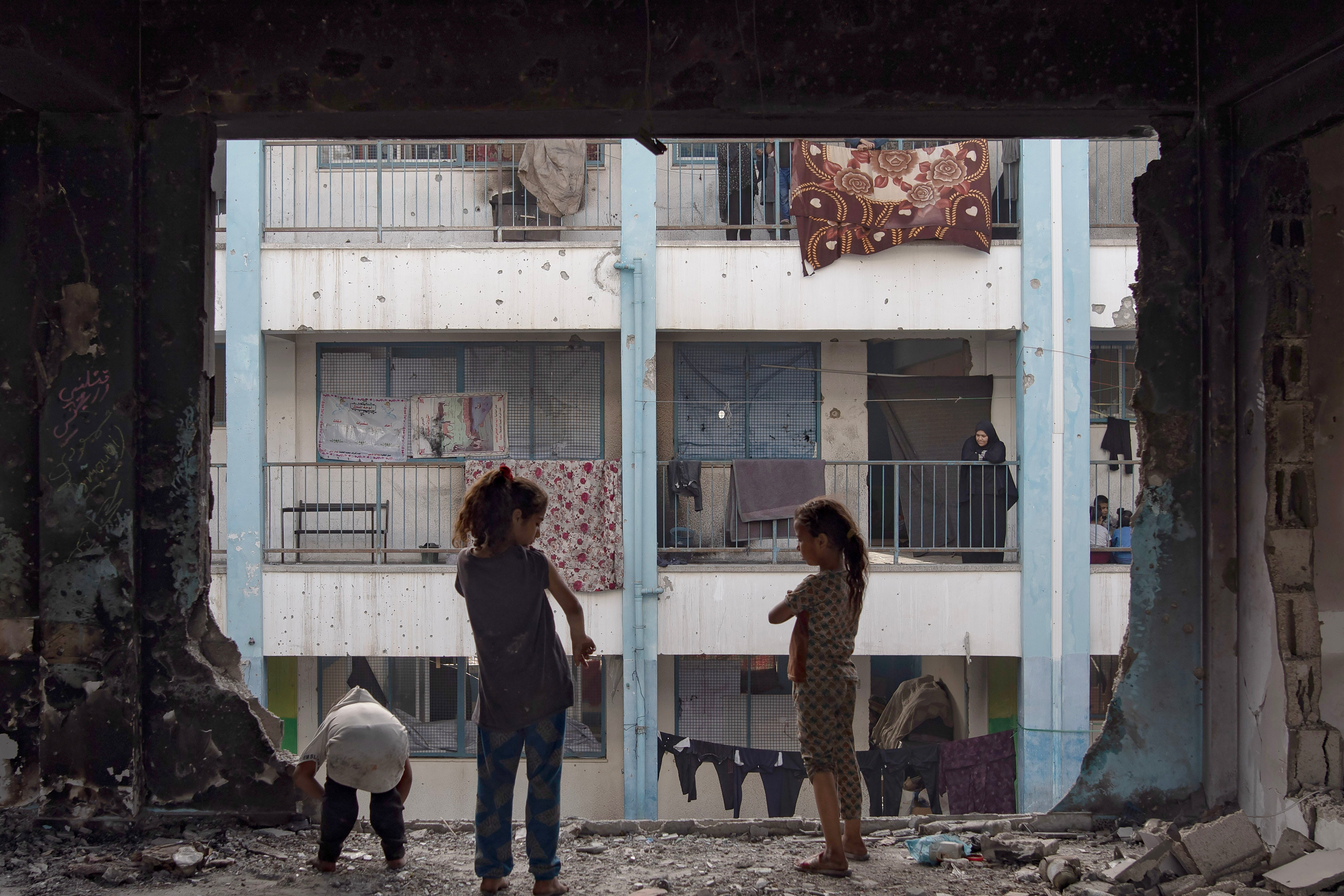 Displaced Palestinians live in a destroyed UNRWA school after the Israeli army asked them to evacuate the city of Rafah, in the Khan Yunis