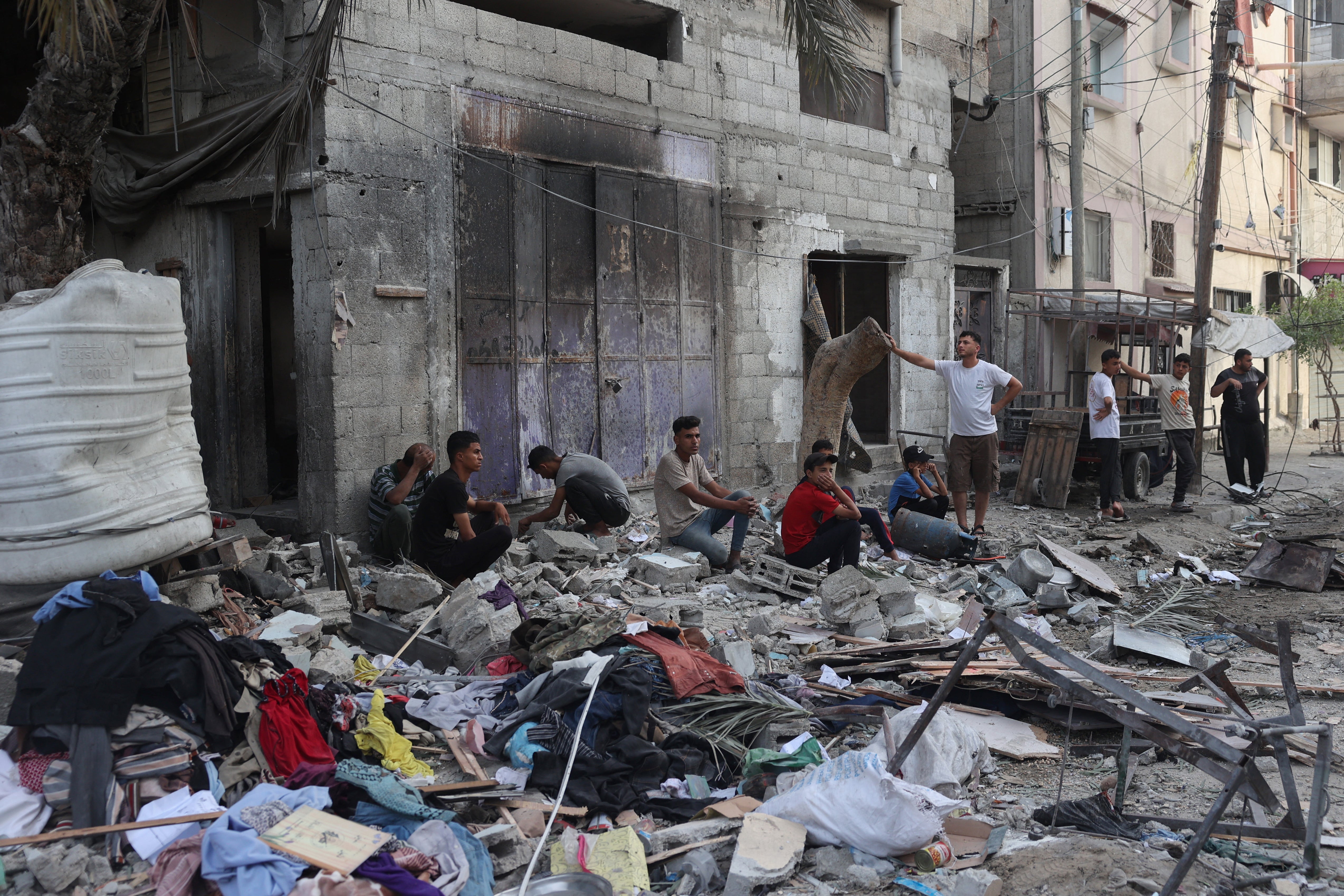 Palestinians sit by the rubble of a family house that was hit overnight in Israeli bombardment in the Tal al-Sultan neighbourhood of Rafah in southern Gaza