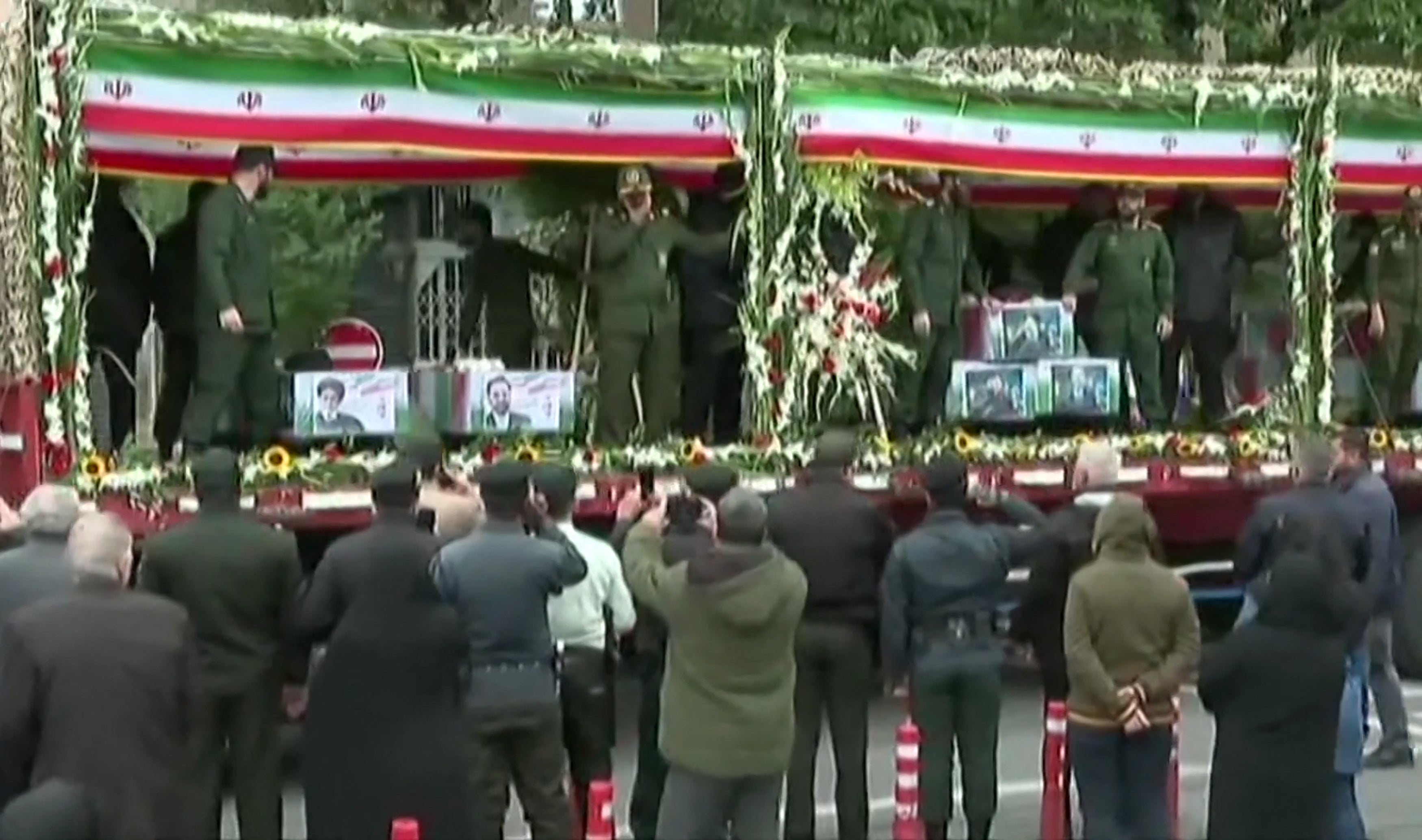 Coffins of the Iranian President and seven members of his entourage are seen on a truck during the funerary procession