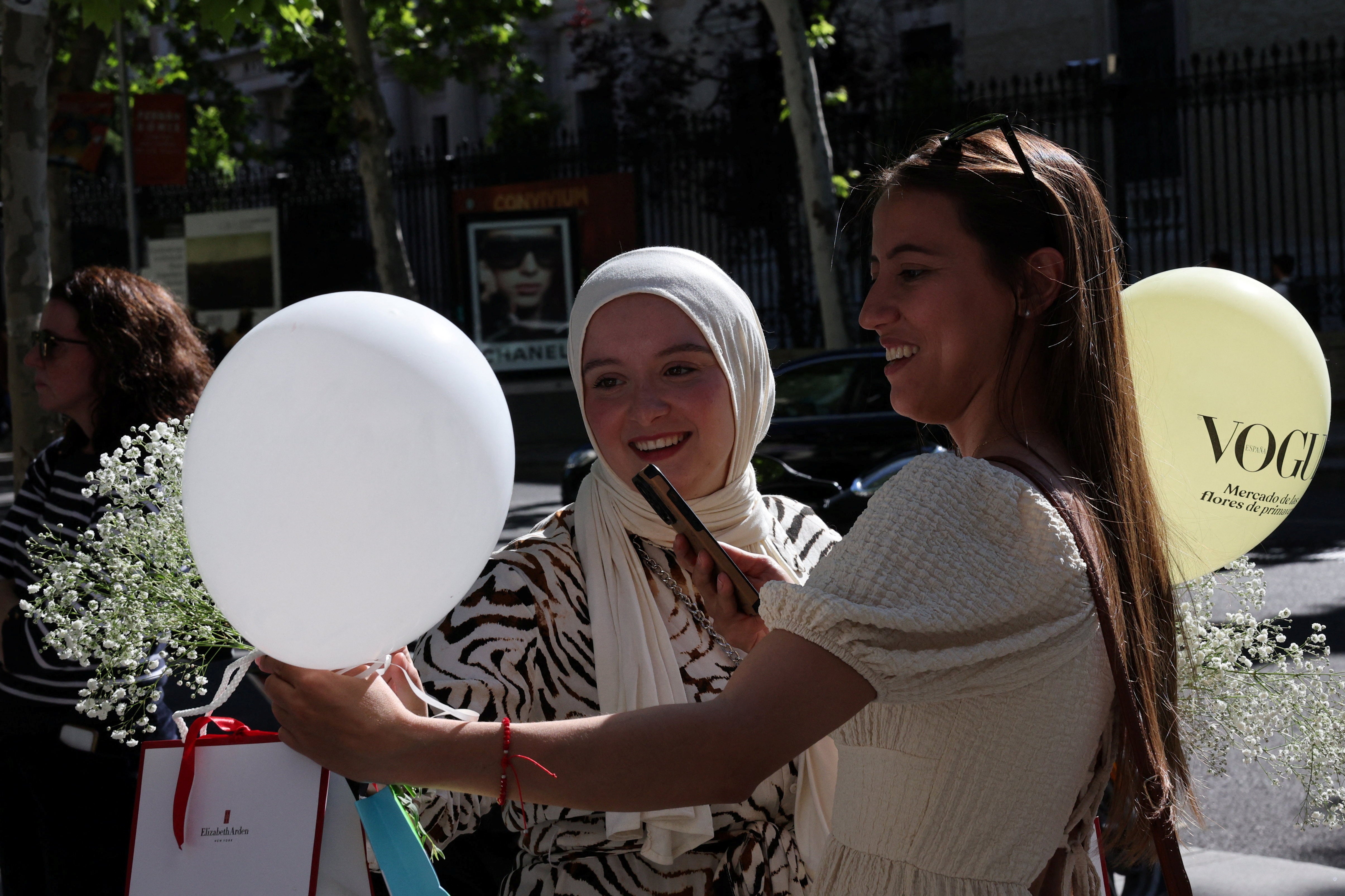 People take photos at an outdoor market in the downtown district of Salamanca, Spain