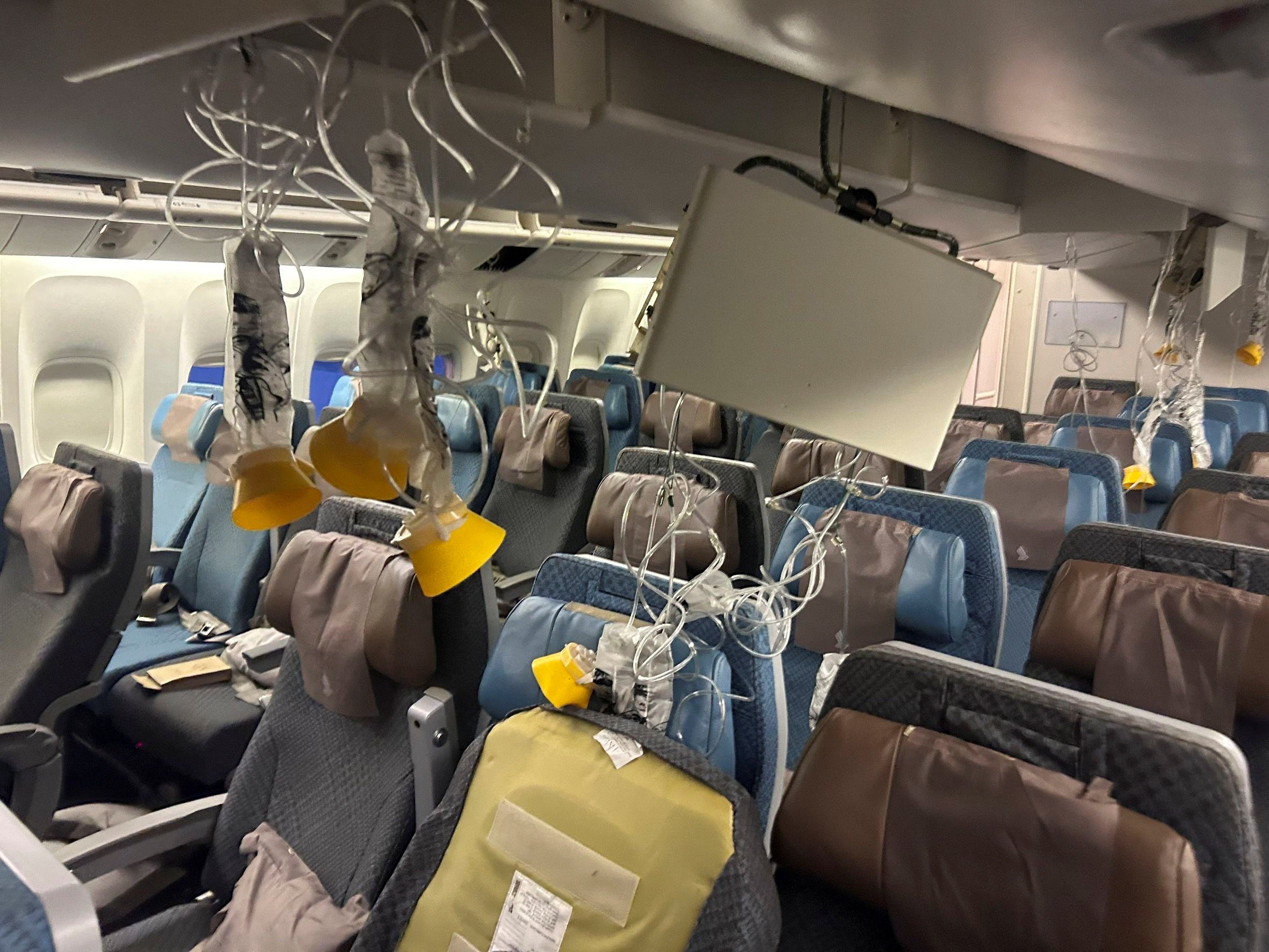 Oxygen masks and debris can be seen in the cabin