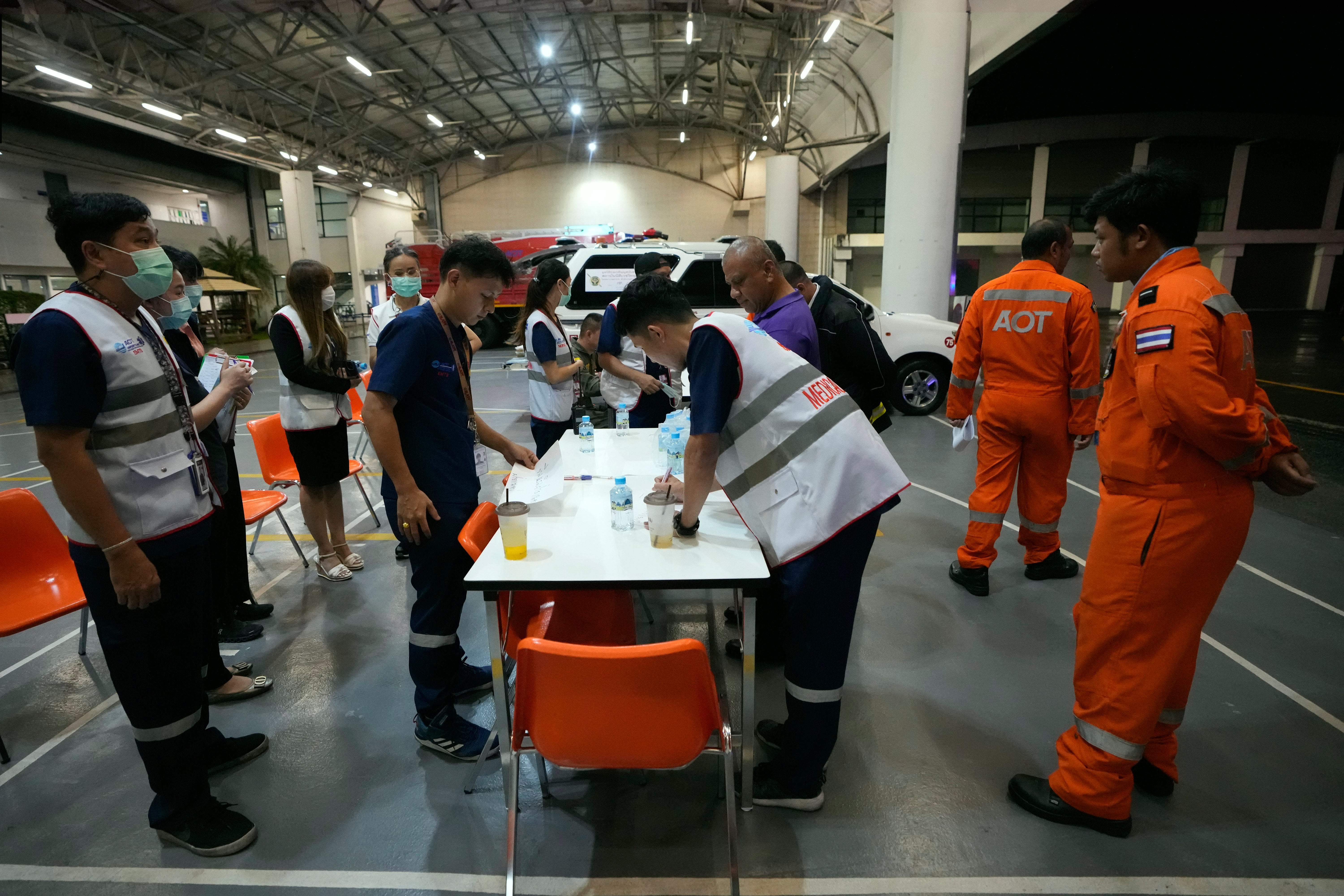 Members of a rescue team discuss after a London-Singapore flight was diverted to Bangkok due to severe turbulence, in Bangkok