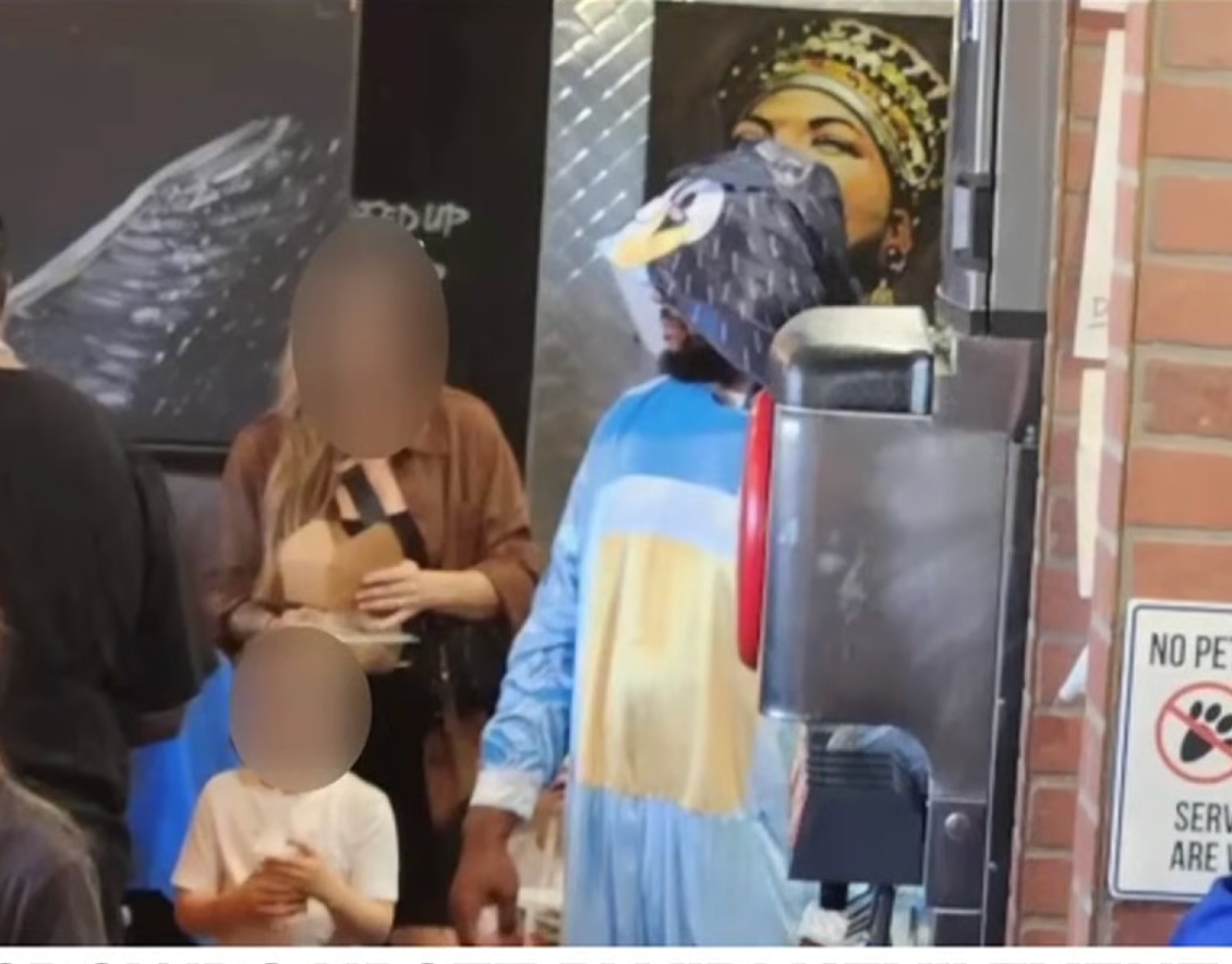 Mom and child next to the restaurant worker dressed as Bluey