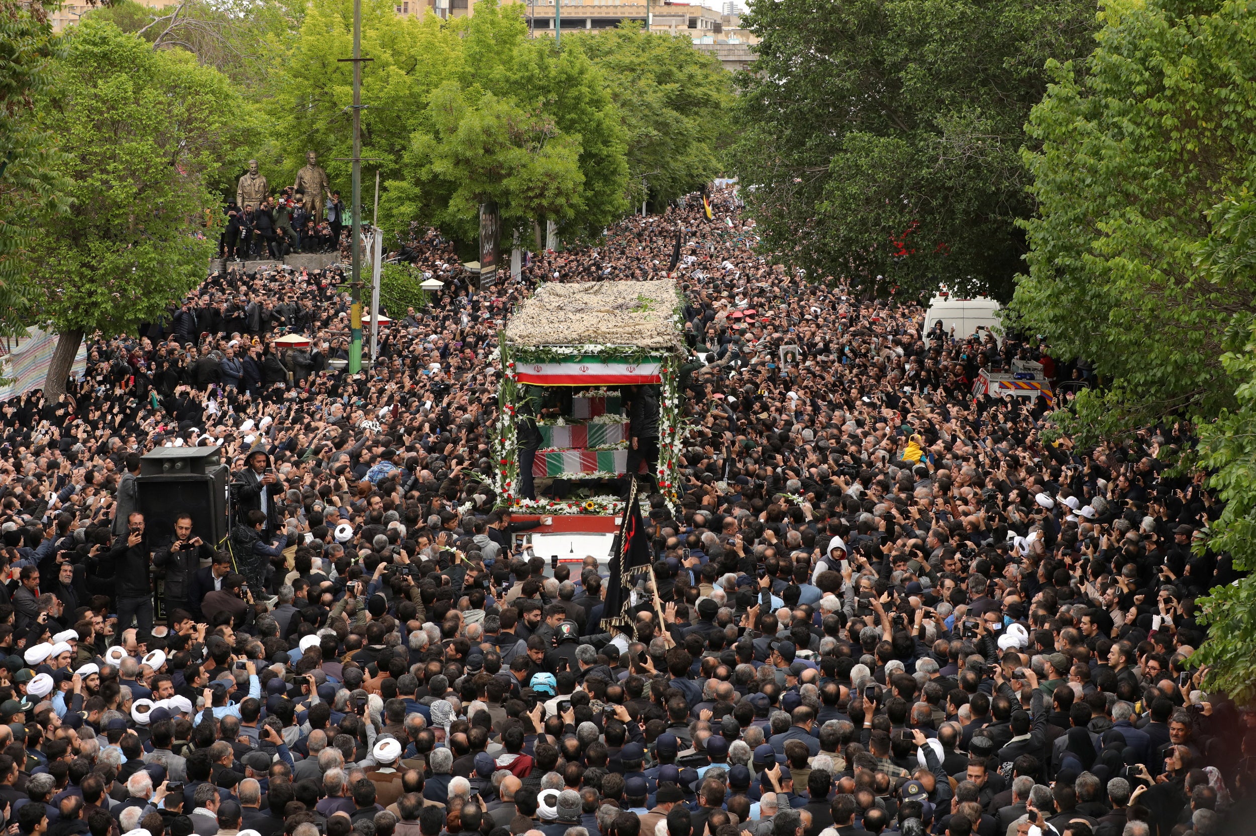 Thousands swarm a truck carrying the late Iranian President Ebrahim Raisi in the northwest city of Tabriz