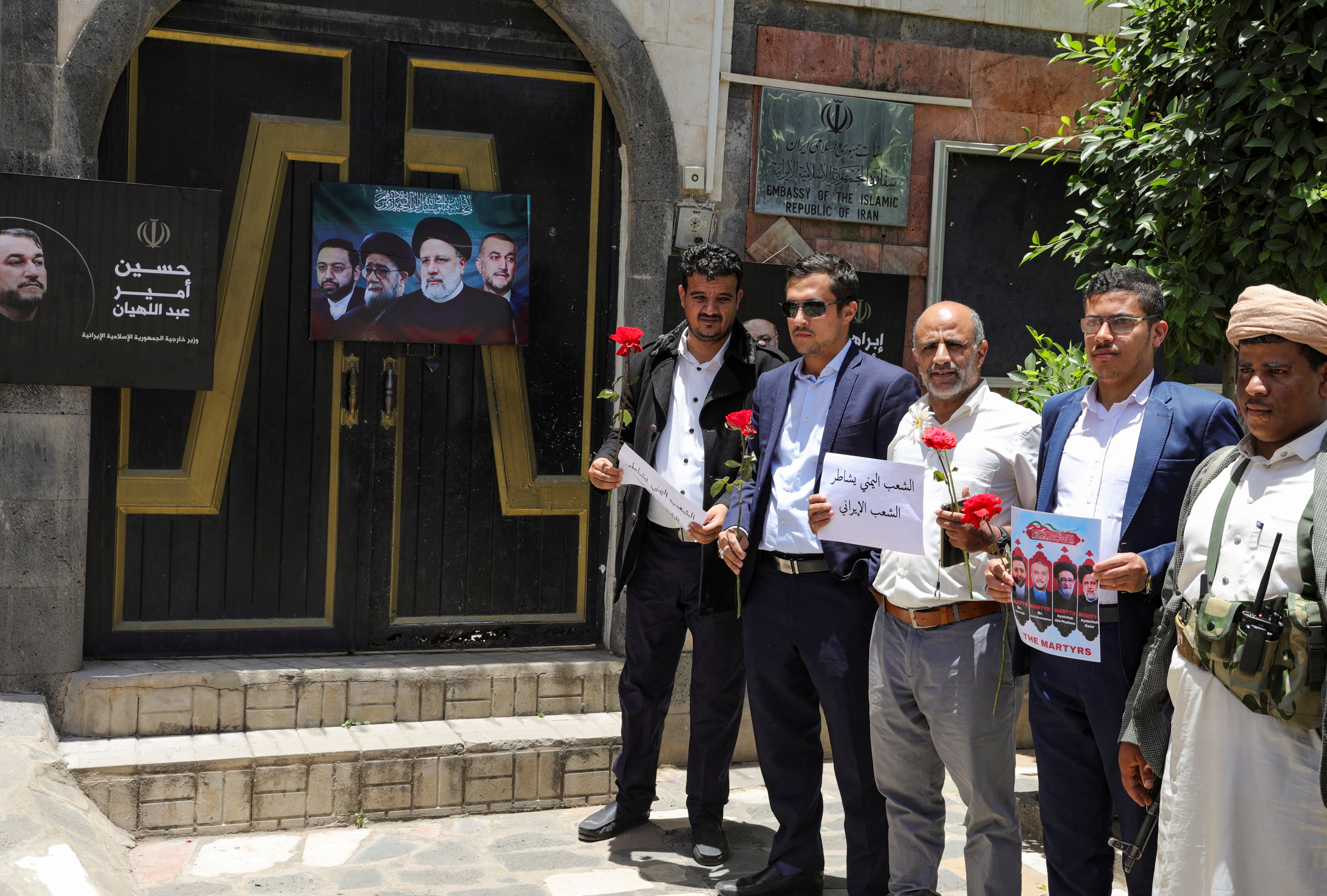 Houthi activists stand outside the Iranian embassy in Sanaa, Yemen as they offer condolences over Raisi’s death