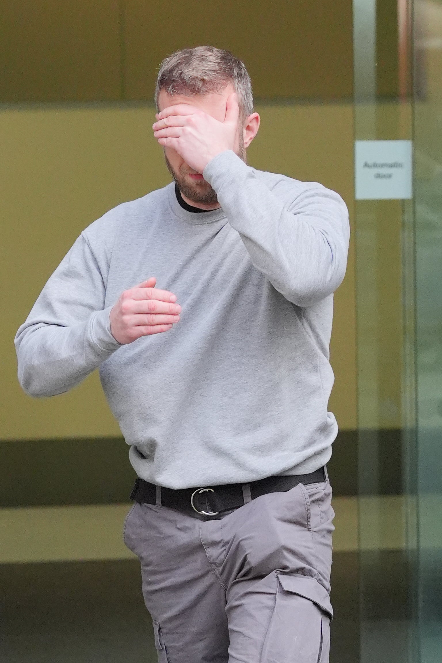 Matthew Trickett covering his face as he left Westminster Magistrates’ Court, central London, after appearing in court accused of assisting the Hong Kong intelligence service