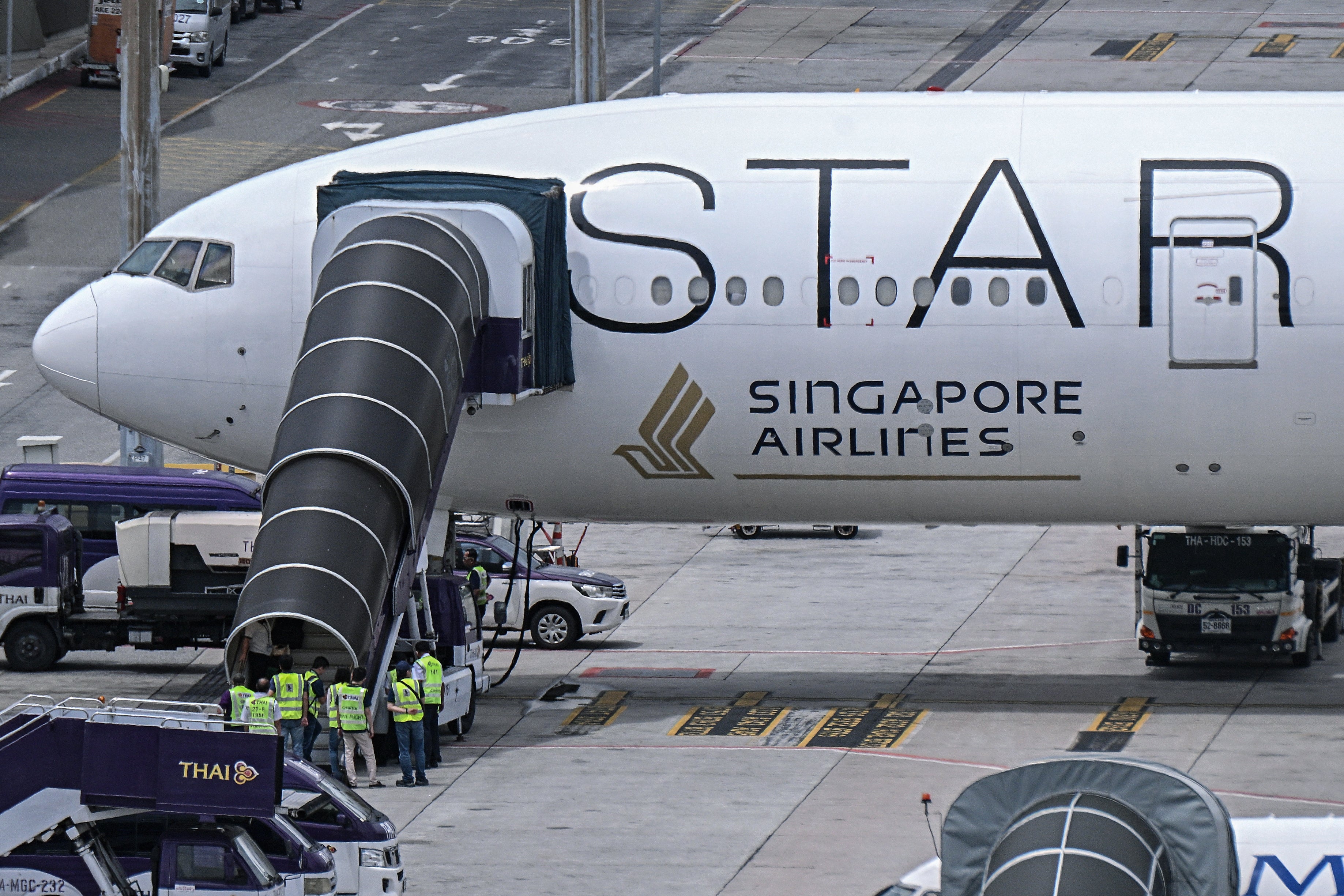 Officials enter the Singapore Airlines Boeing 777-300ER airplane that made an emergency landing in Bangkok due to severe turbulence