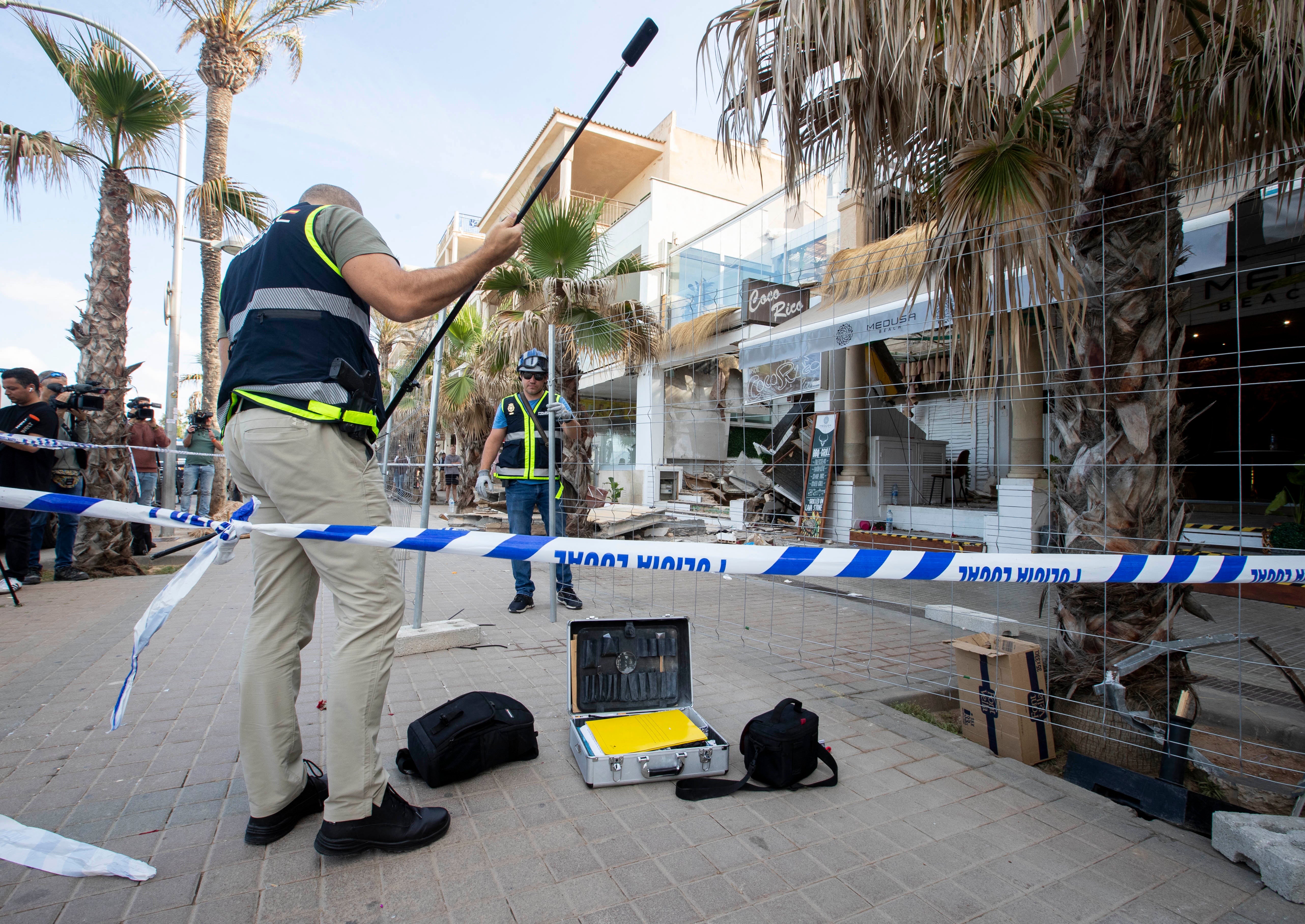 Police officers investigate one day after the two-storey restaurant collapsed