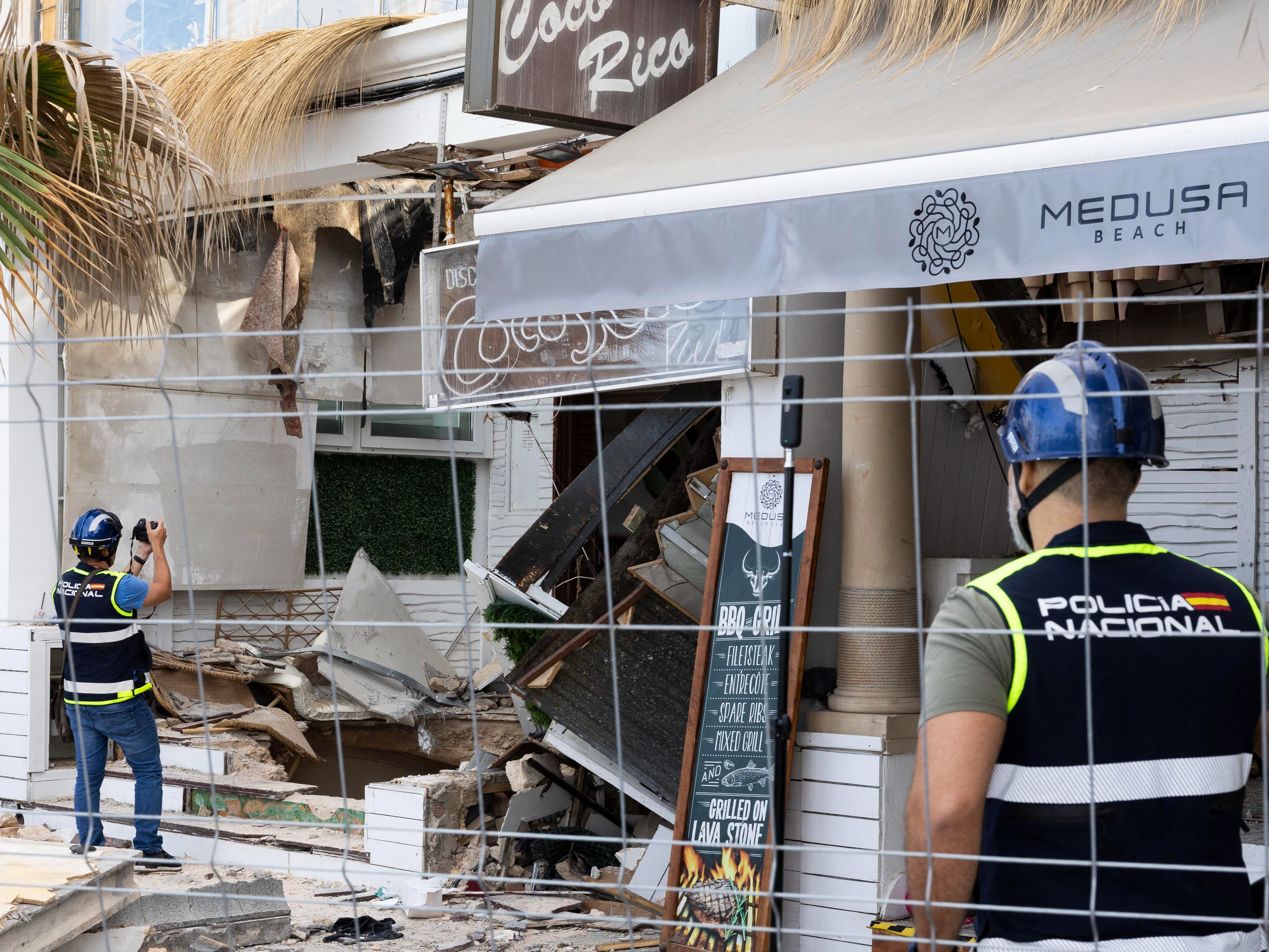 Police officers investigate one day after a two-storey restaurant collapsed