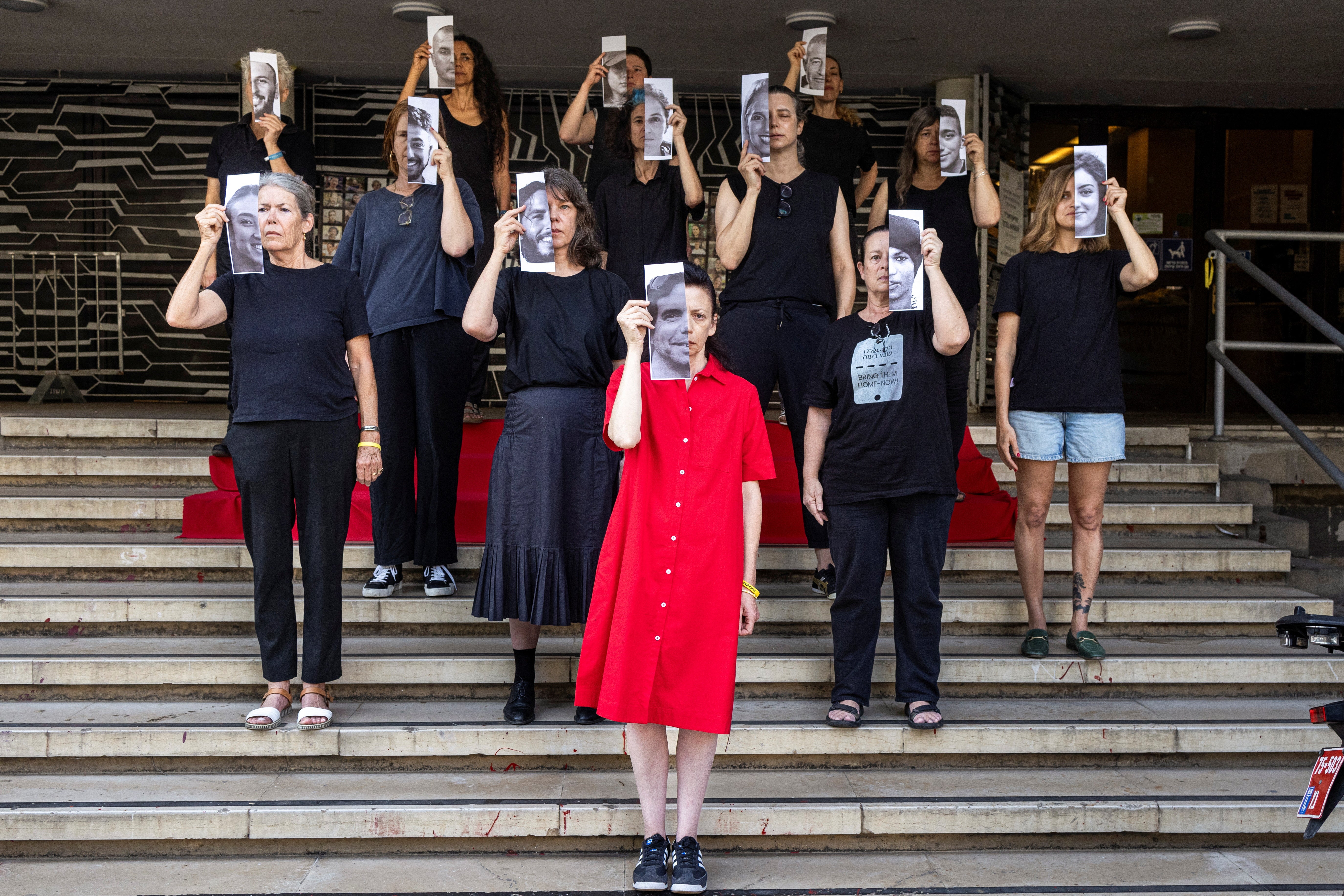 Relatives and supporters hold pictures of hostages kidnapped into Gaza during a Tel Aviv protest calling for their return