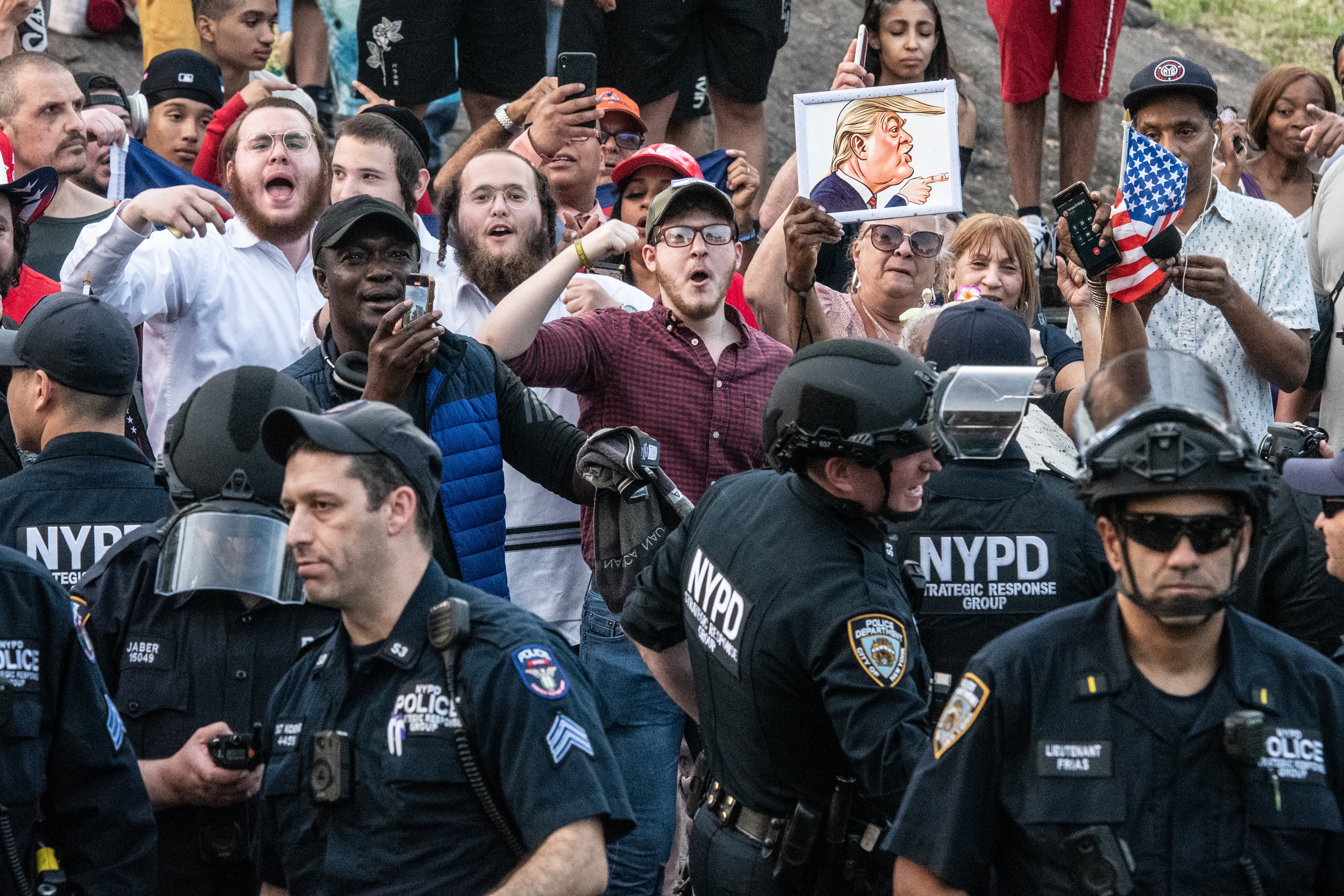 Protesters and supporters of Trump are separated by the NYPD outside the Crotona Park rally venue