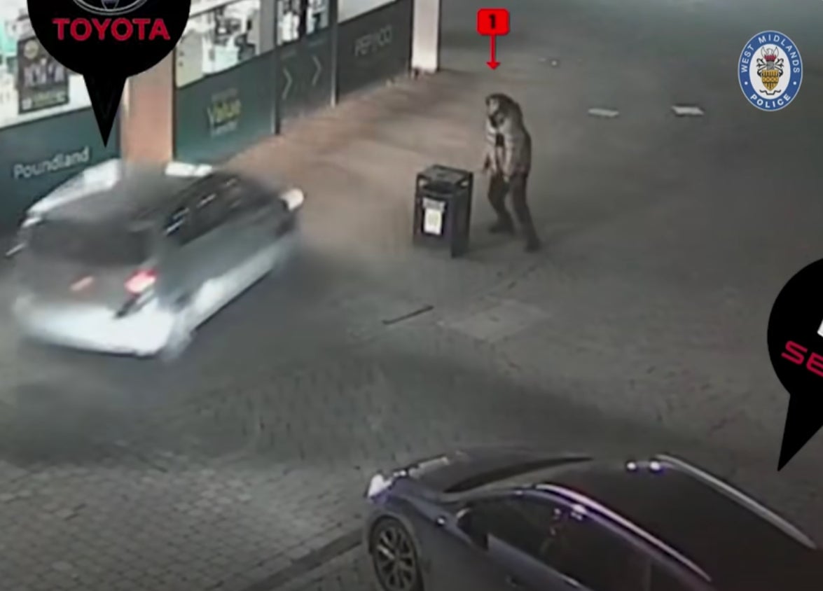 Mr Atkinson tries to hide behind a bin as a car drives straight at him