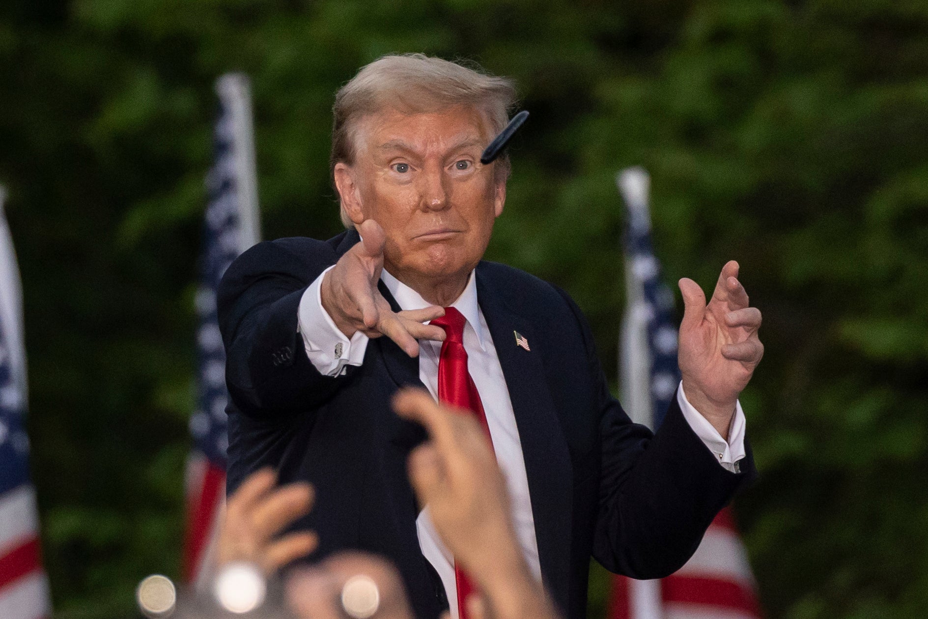 Former President Donald Trump throws a pen during a campaign rally in the south Bronx on May 23