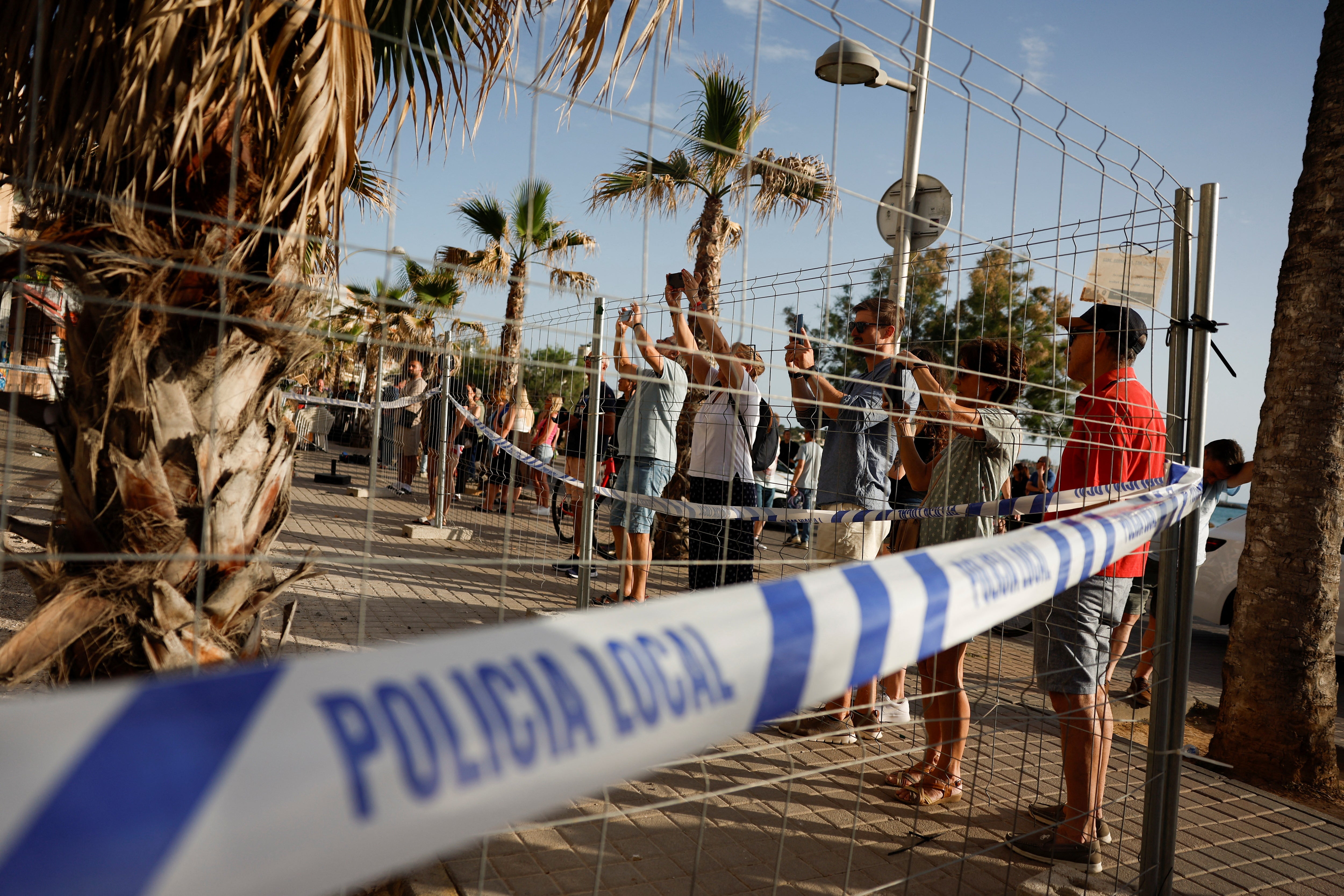 Tourists take pictures of the Medusa Beach Club building after its collapse, in Palma de Mallorca, Spain