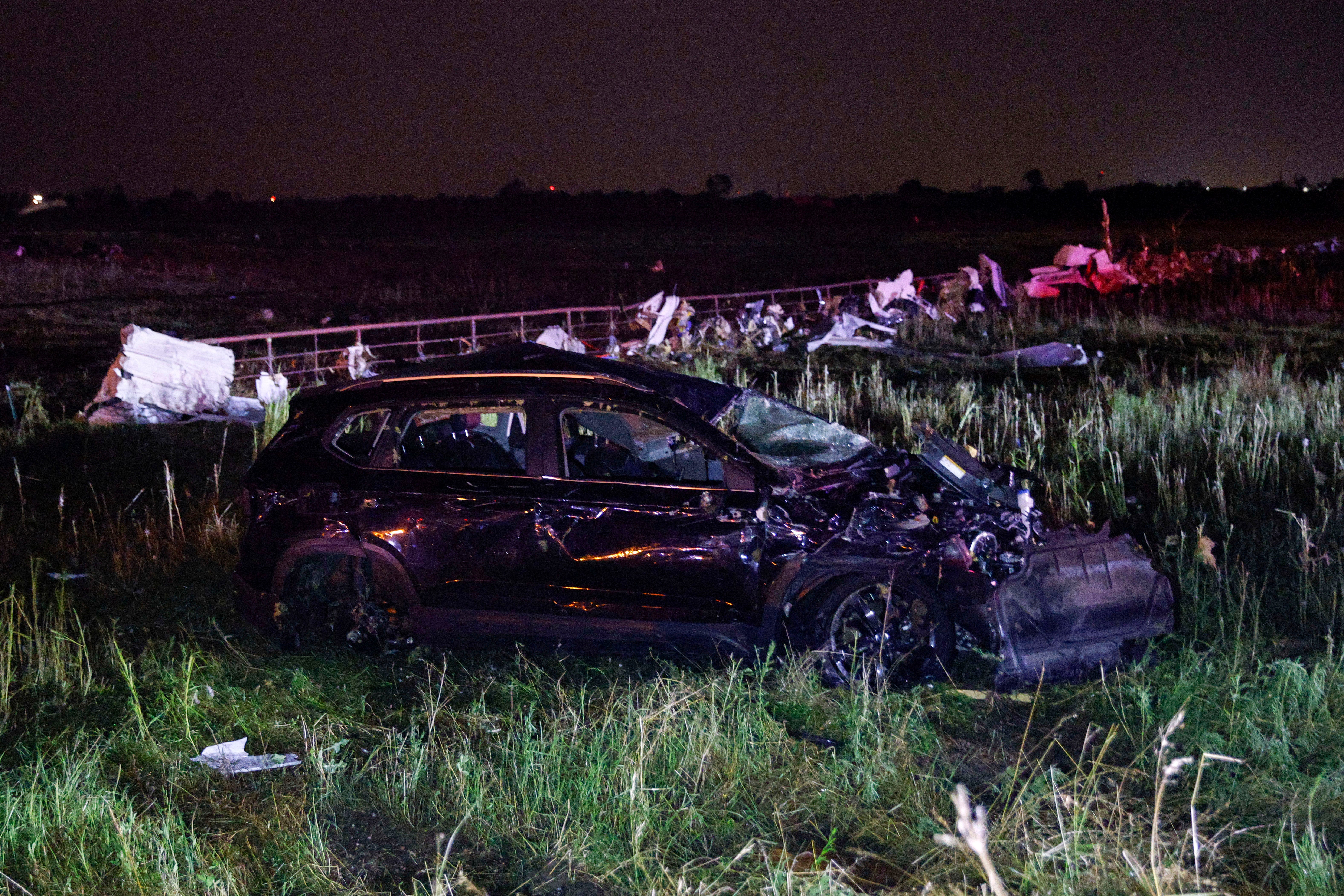 An SUV is seen in a field near a Shell gas station after a suspected tornado moved through the area, Sunday, May 26, 2024, in Valley View, Texas