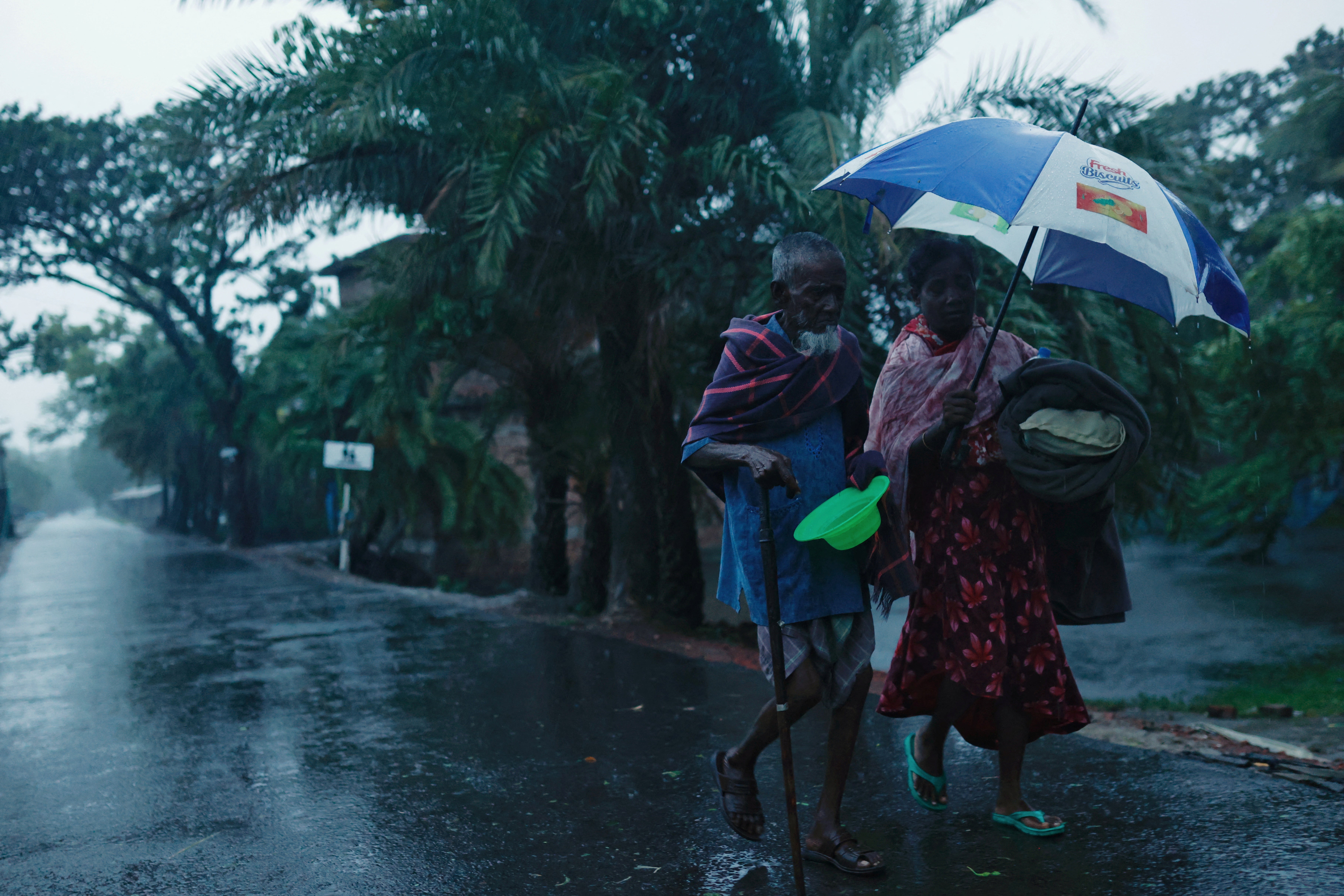 People move with their belongings to the cyclone shelter before Cyclone Remal in Satkhira