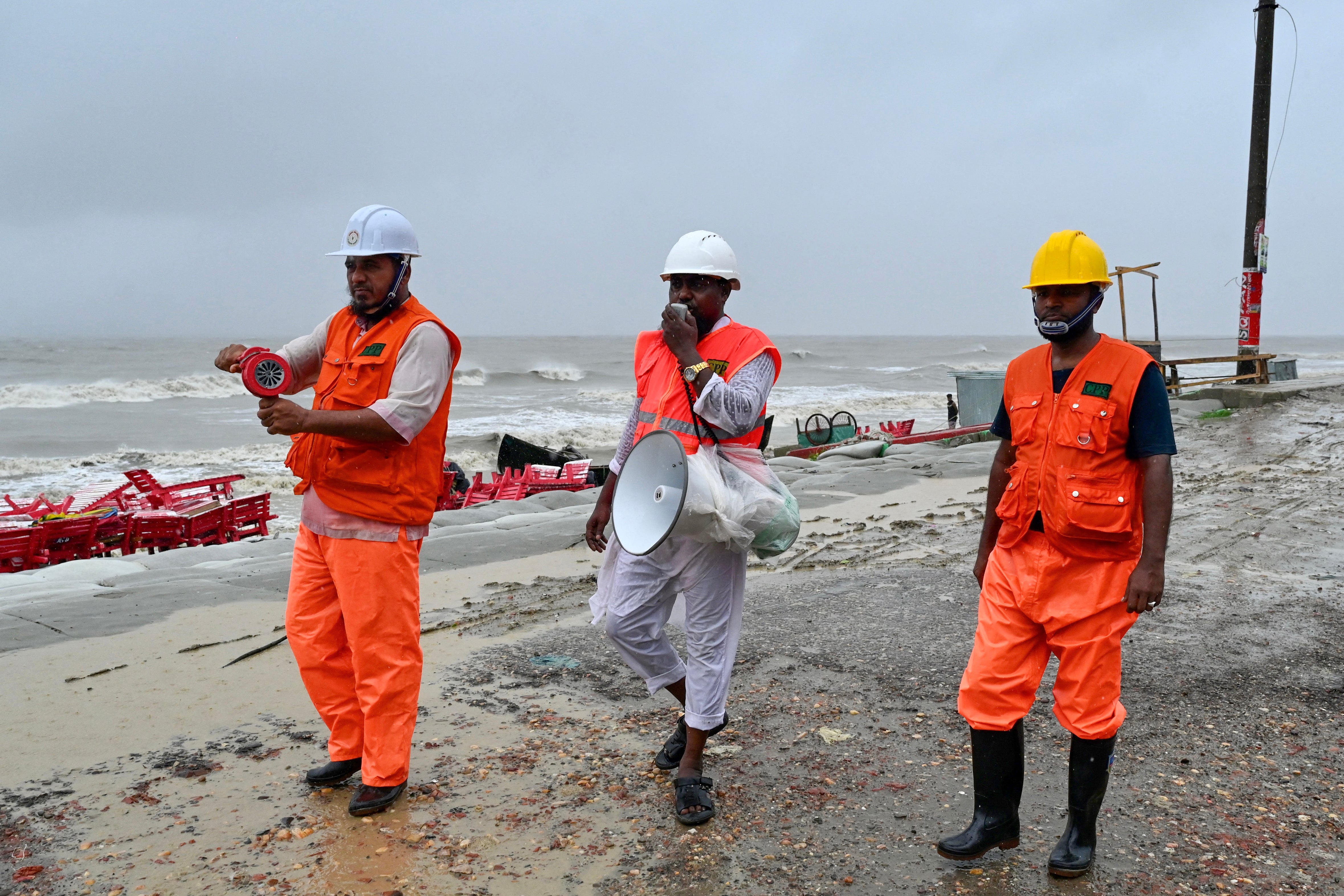 Volunteers of the Cyclone Preparedness Programm (CPP) use a megaphone to alert people asking them to evacuate as a preventive measure in Kuakata on 26 May 2024