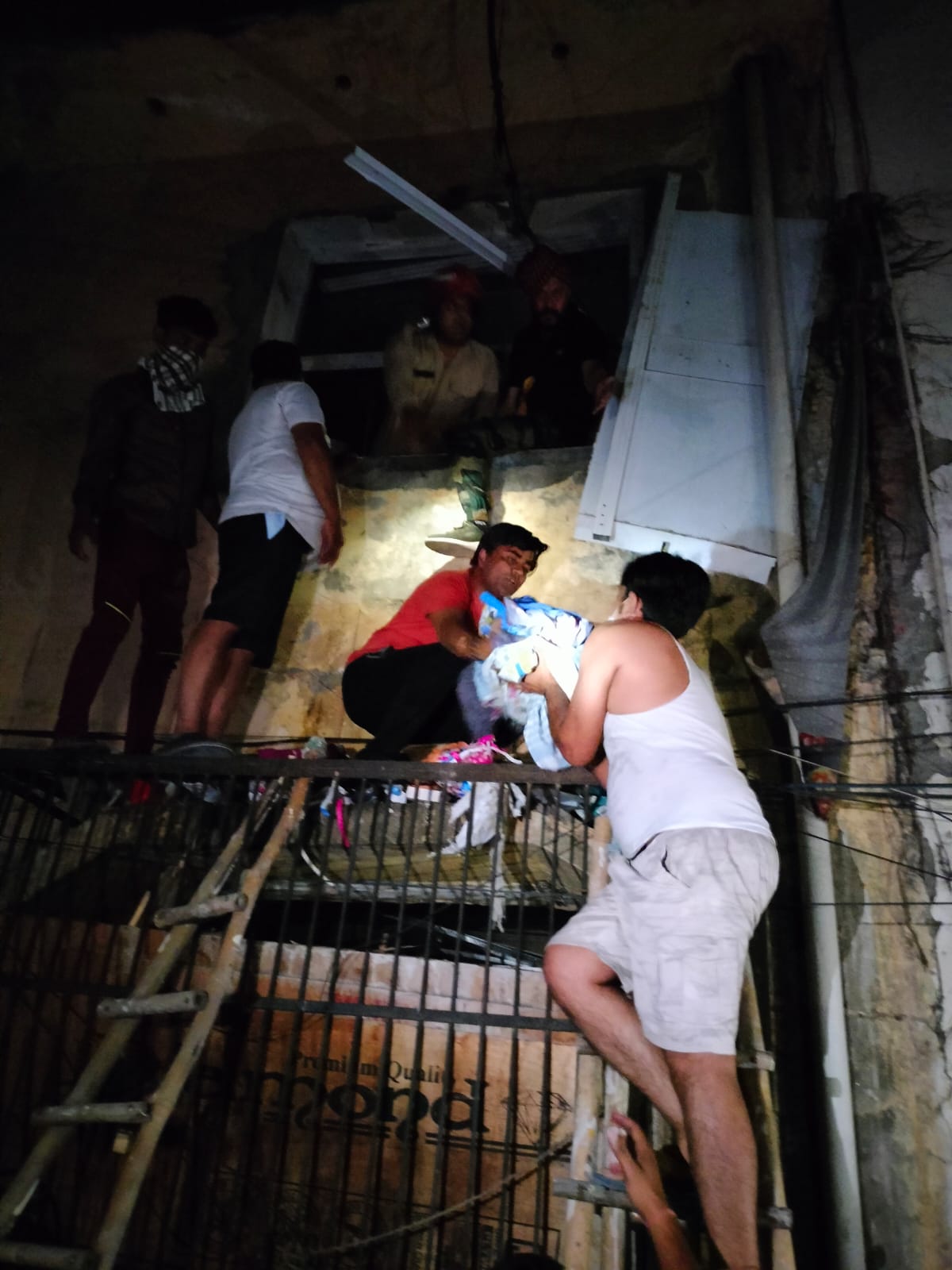 People from the neighbourhood work to pull out newborn from the hospital