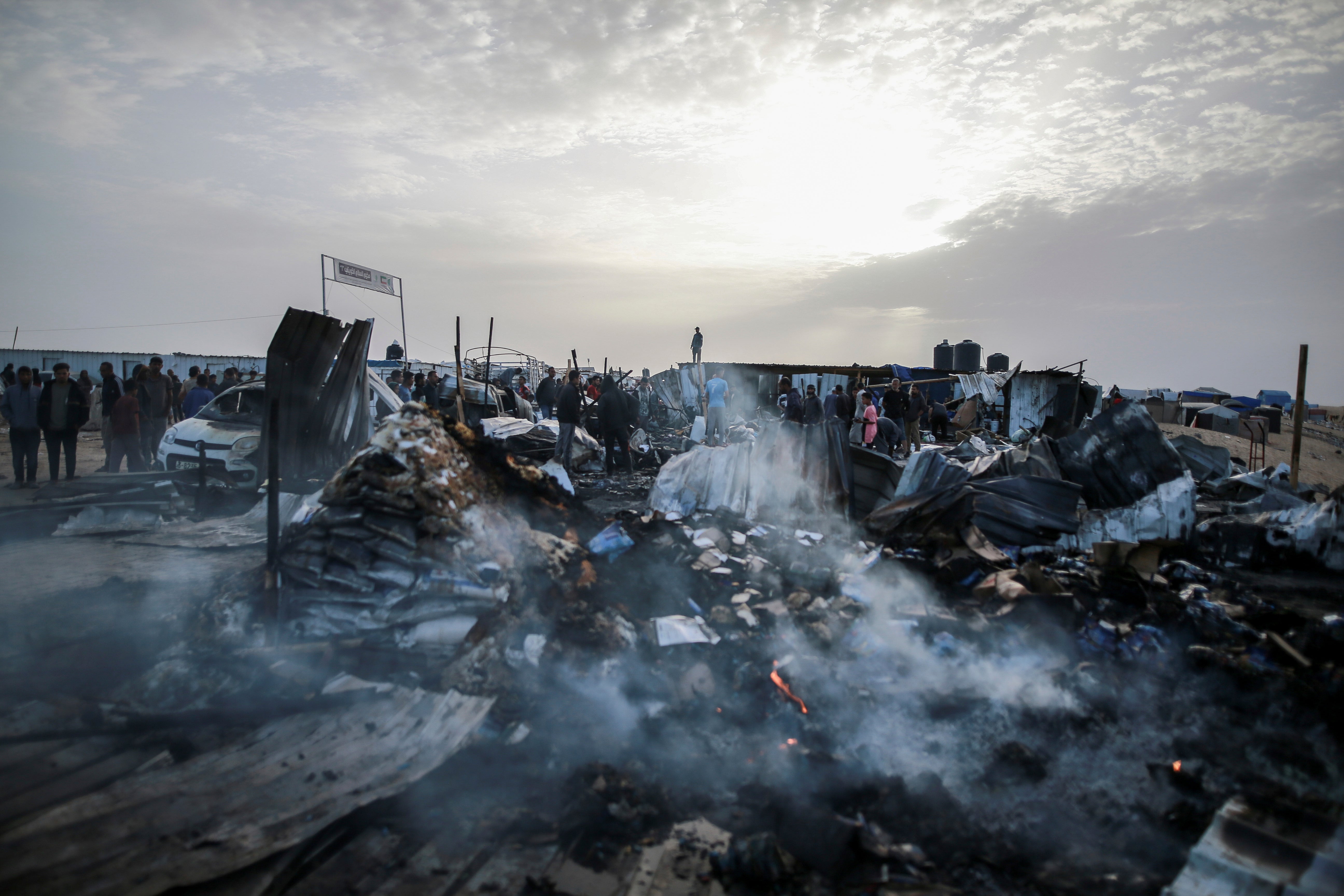 Palestinians look at the destruction after an Israeli strike where displaced people were staying in Rafah, Gaza Strip.