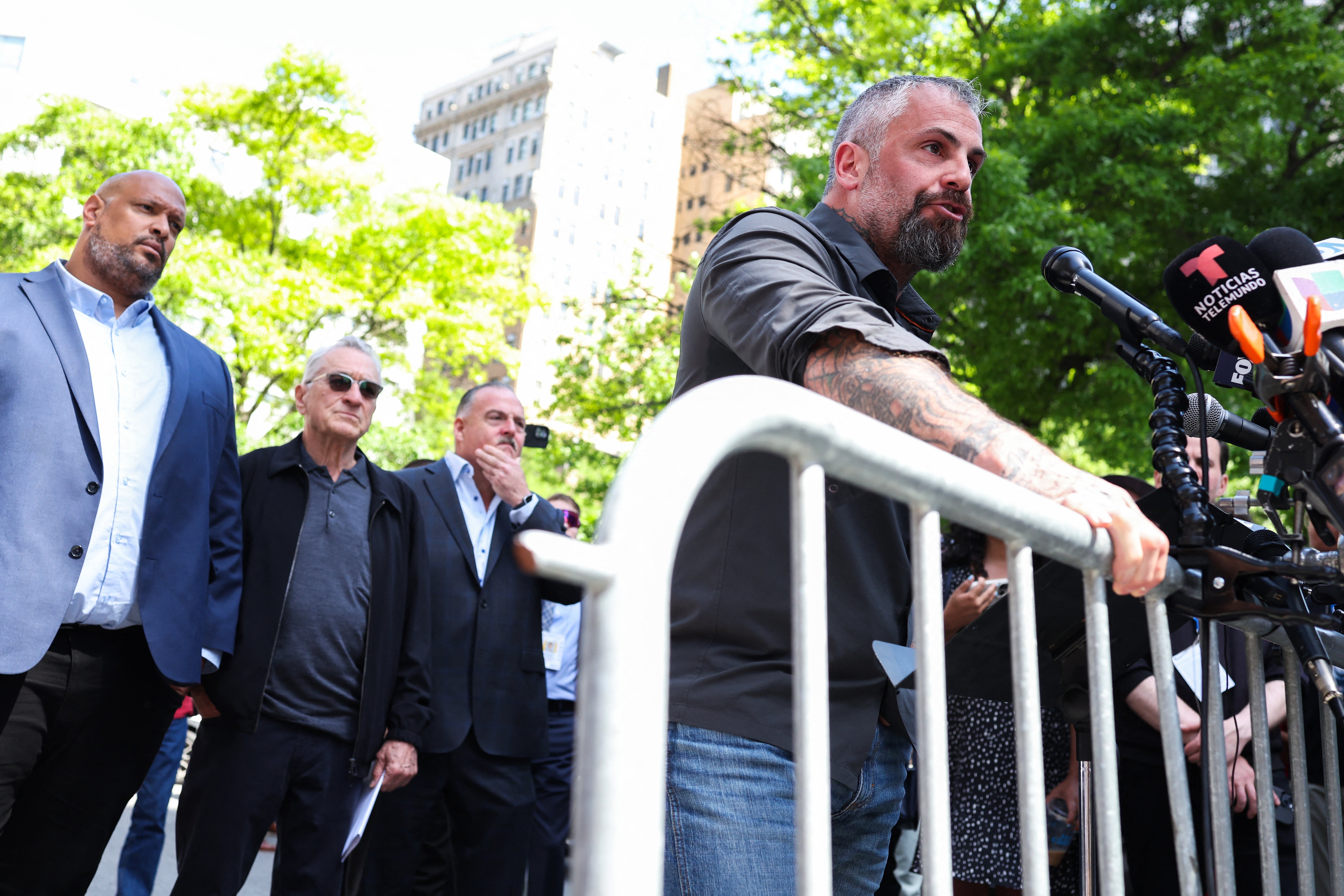 Michael Fanone speaks as Harry Dunn and De Niro looks on