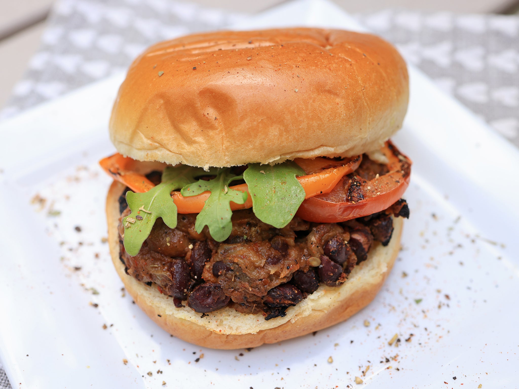 Pulled aubergine and black bean BBQ burgers, served with coleslaw and garnished with rocket and coriander, perfect for a vegan summer grill