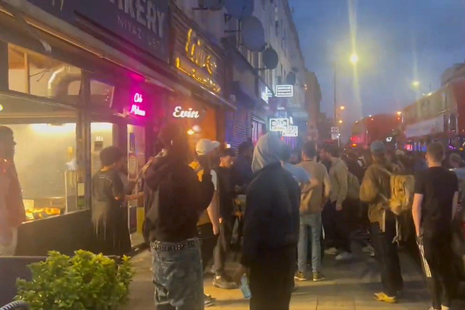 Crowds gathered outside a restaurant in Hackney after a shooting which injured three adults and a child (Ayo Adesina)