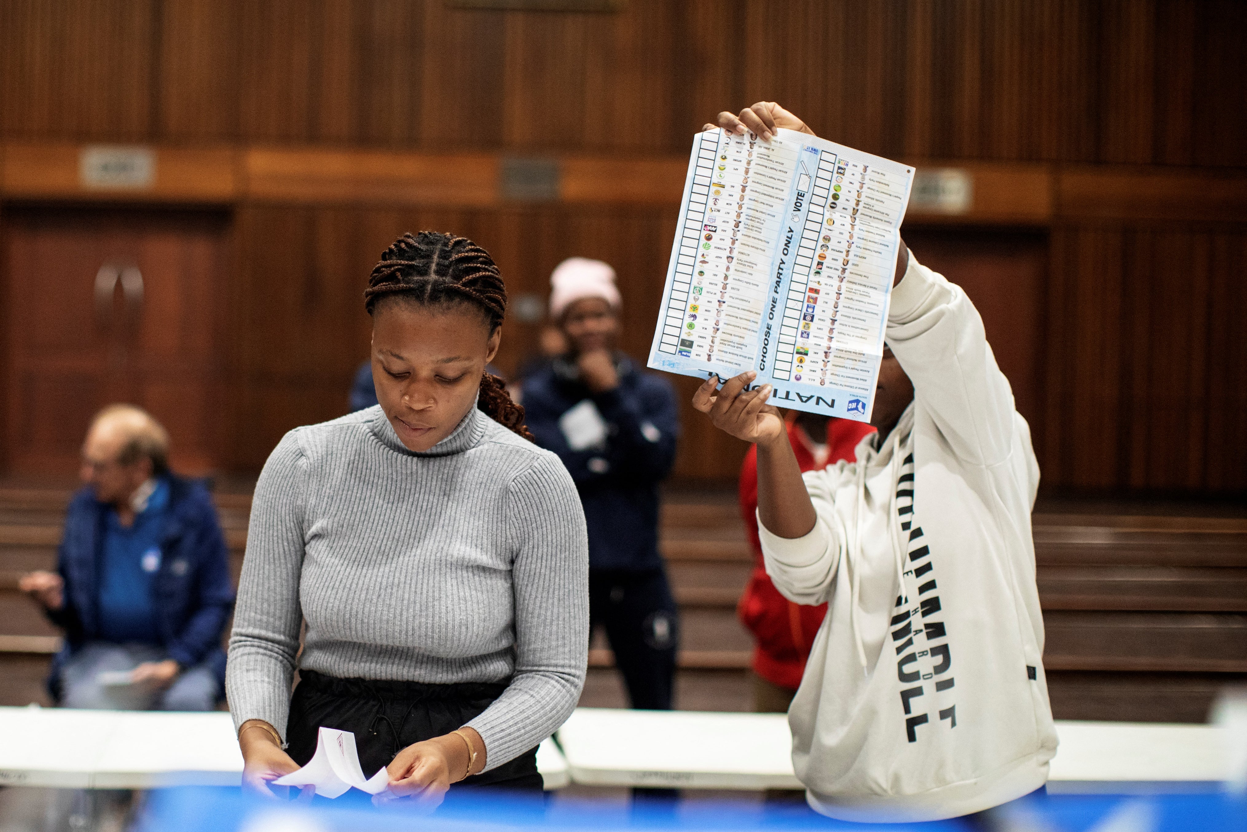 An Electoral Commission of South Africa (IEC) official holds up a marked ballot during the vote counting process