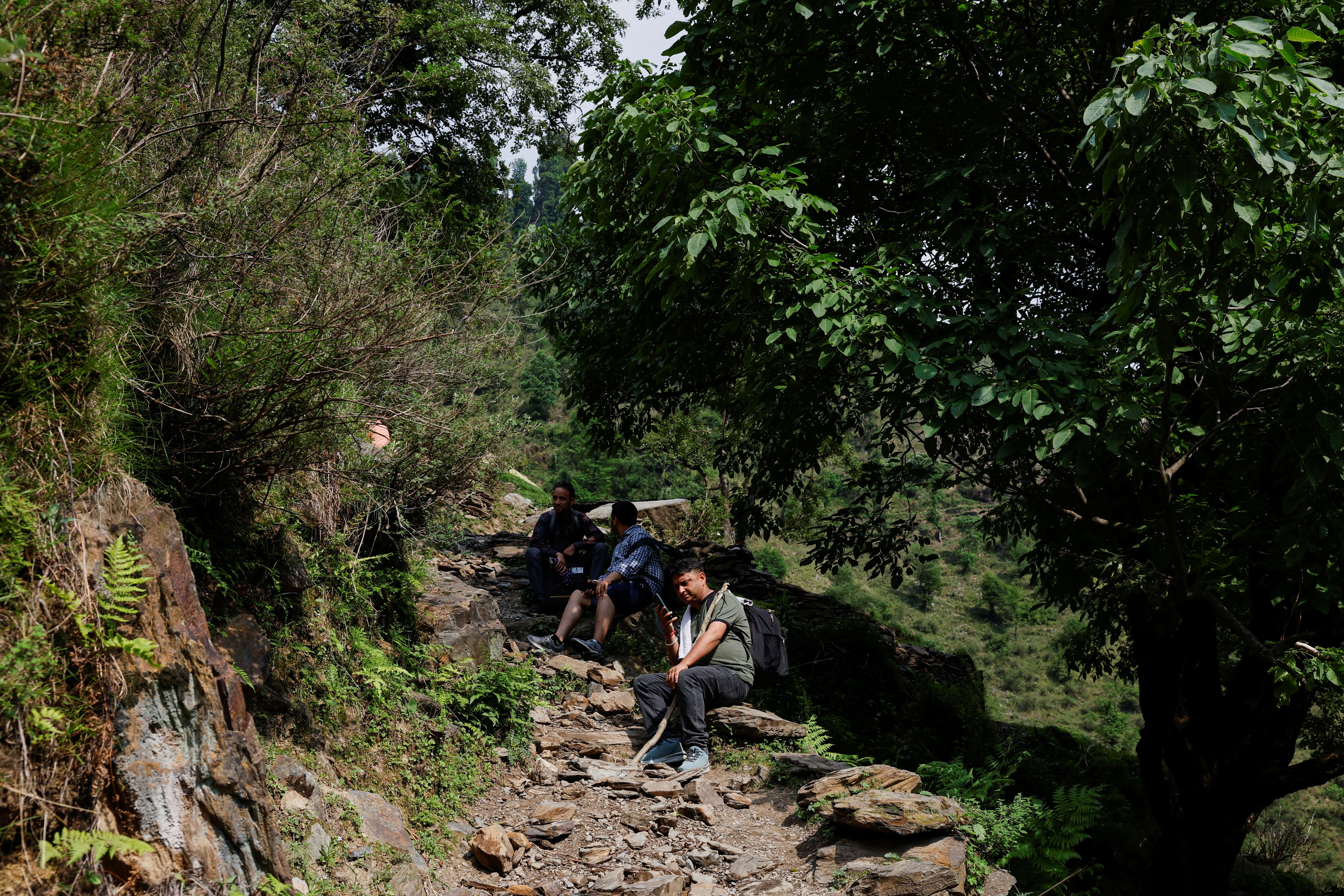 Vishal Aheer, Presiding Election Officer, and his team of polling officials rest during a trek in the mountains to reach a remote polling station, ahead of the seventh and final phase of the elections