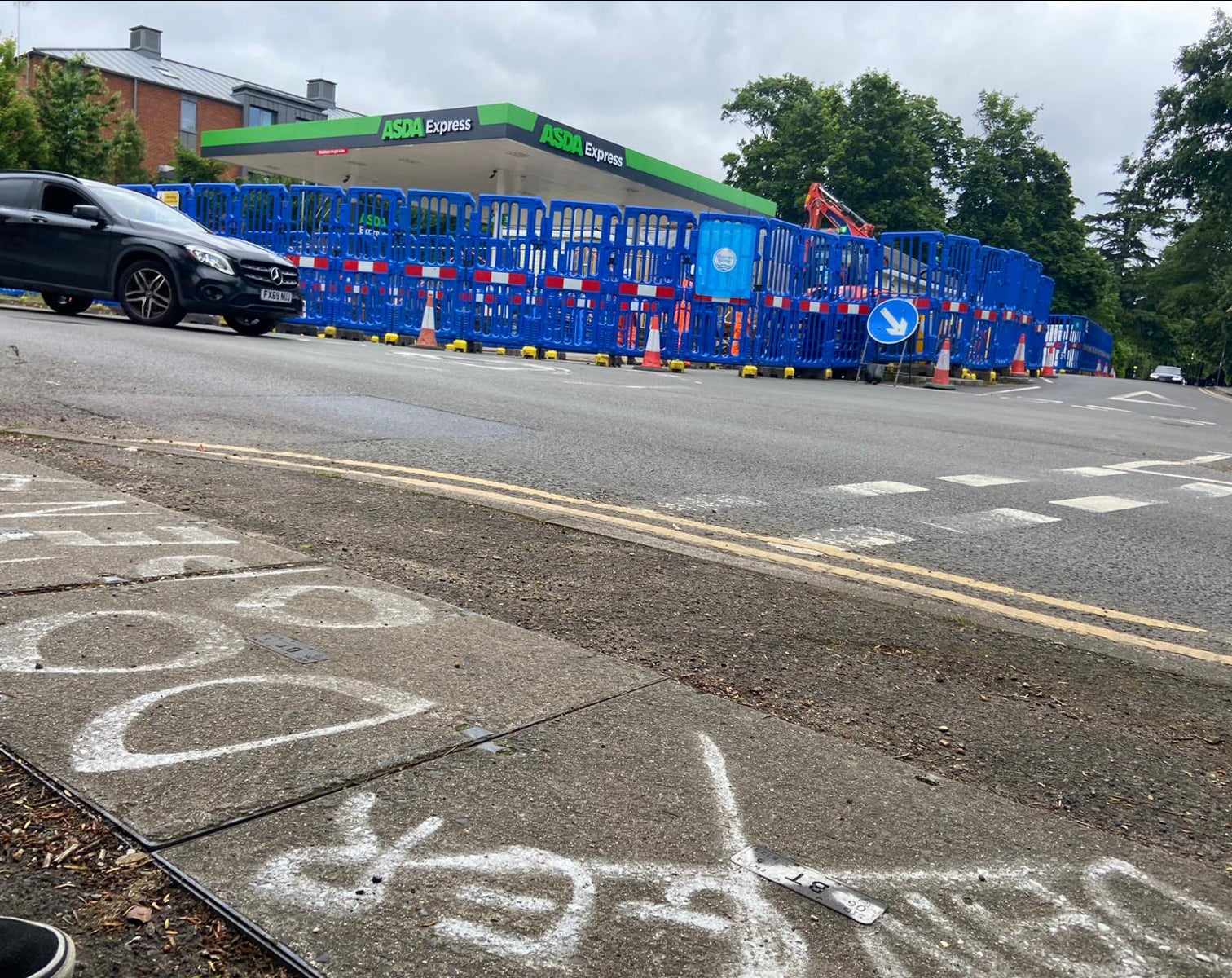 A warning of ‘danger, do not open’ is painted on a manhole cover opposite the petrol station