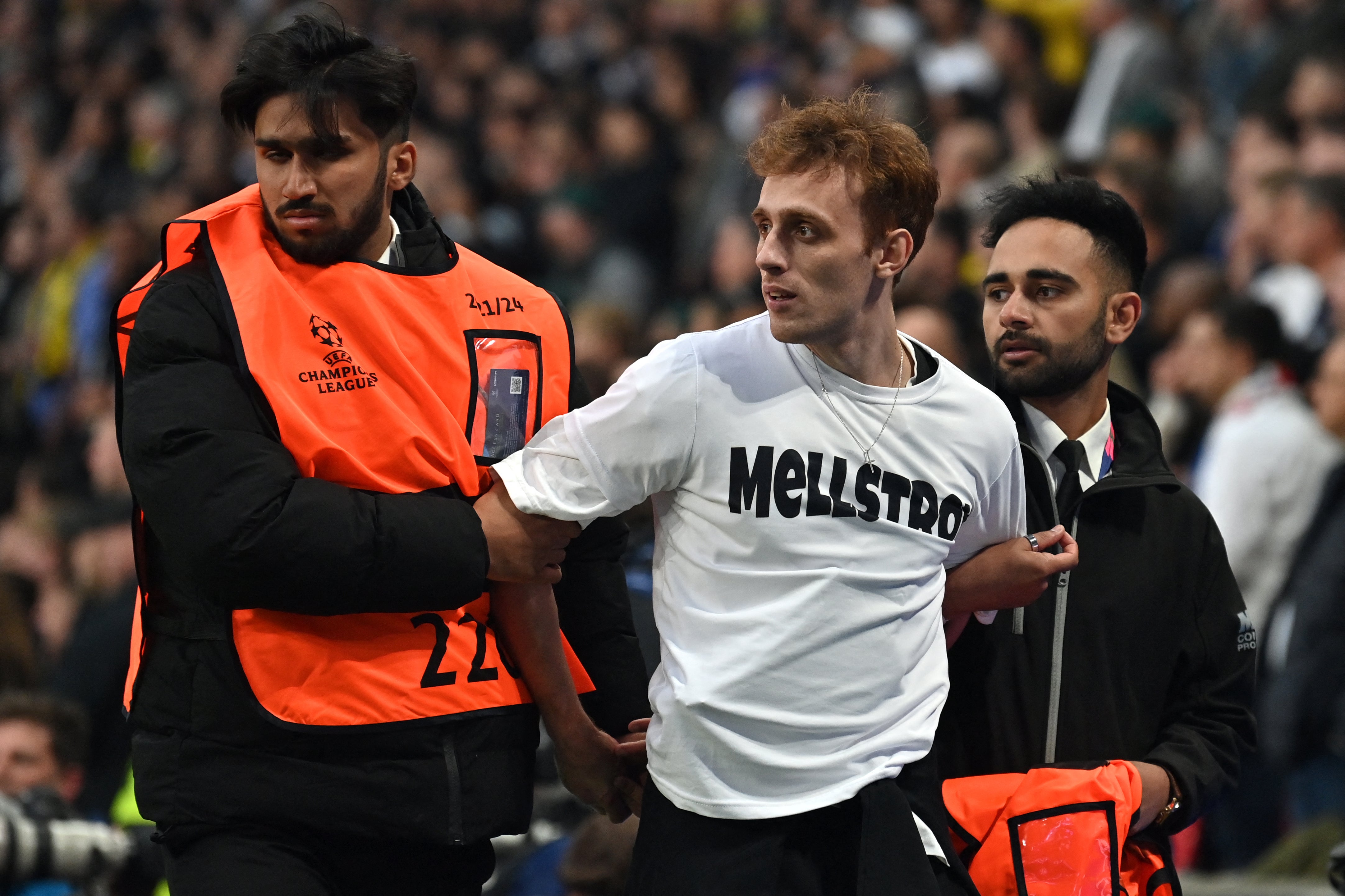 A pitch invader is led away by security