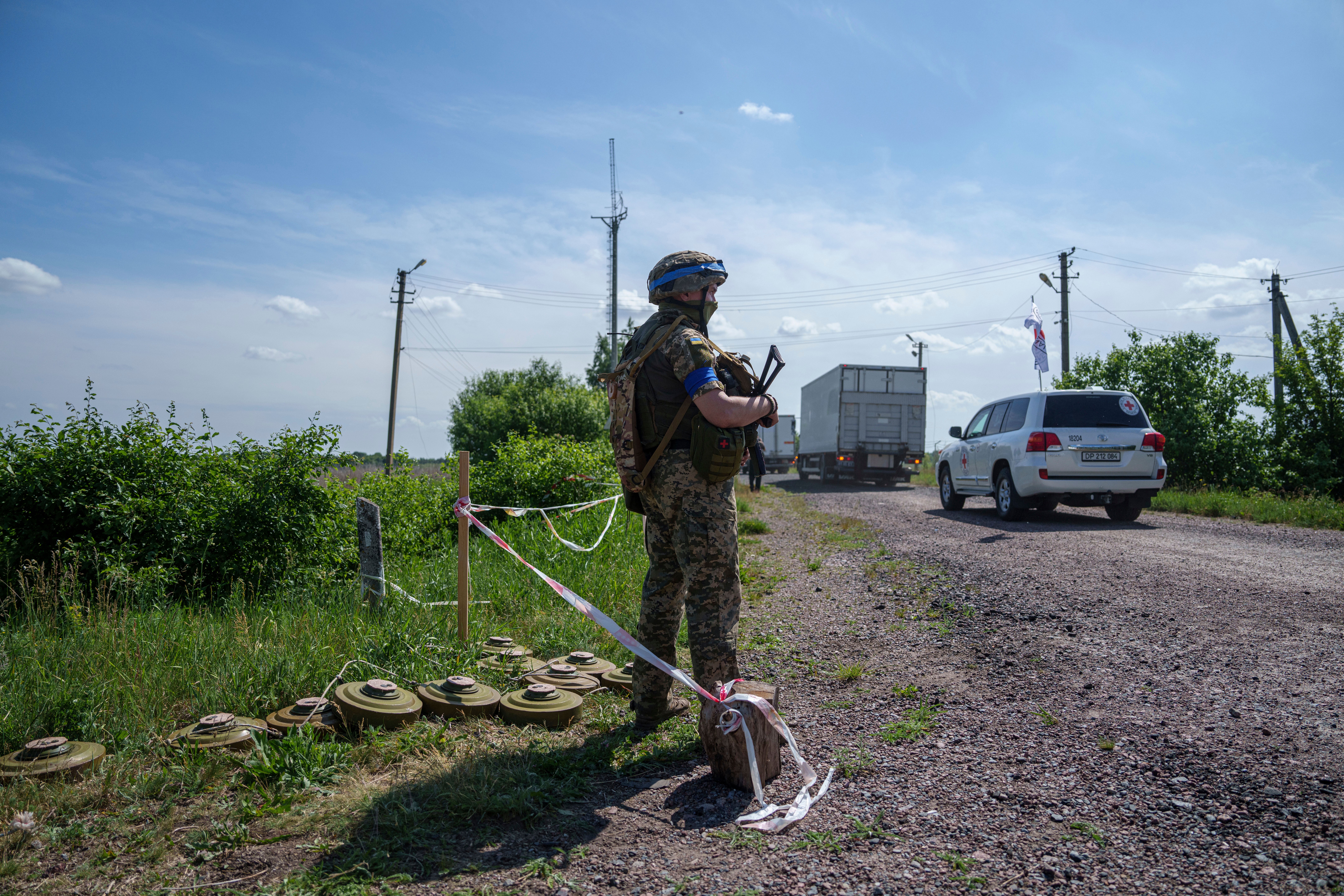 FILE: A Ukrainian soldier guards his position while trucks with killed Russian soldiers driving to Russian territory, during repatriation in Sumy region, Ukraine, Friday, 31 May 2024